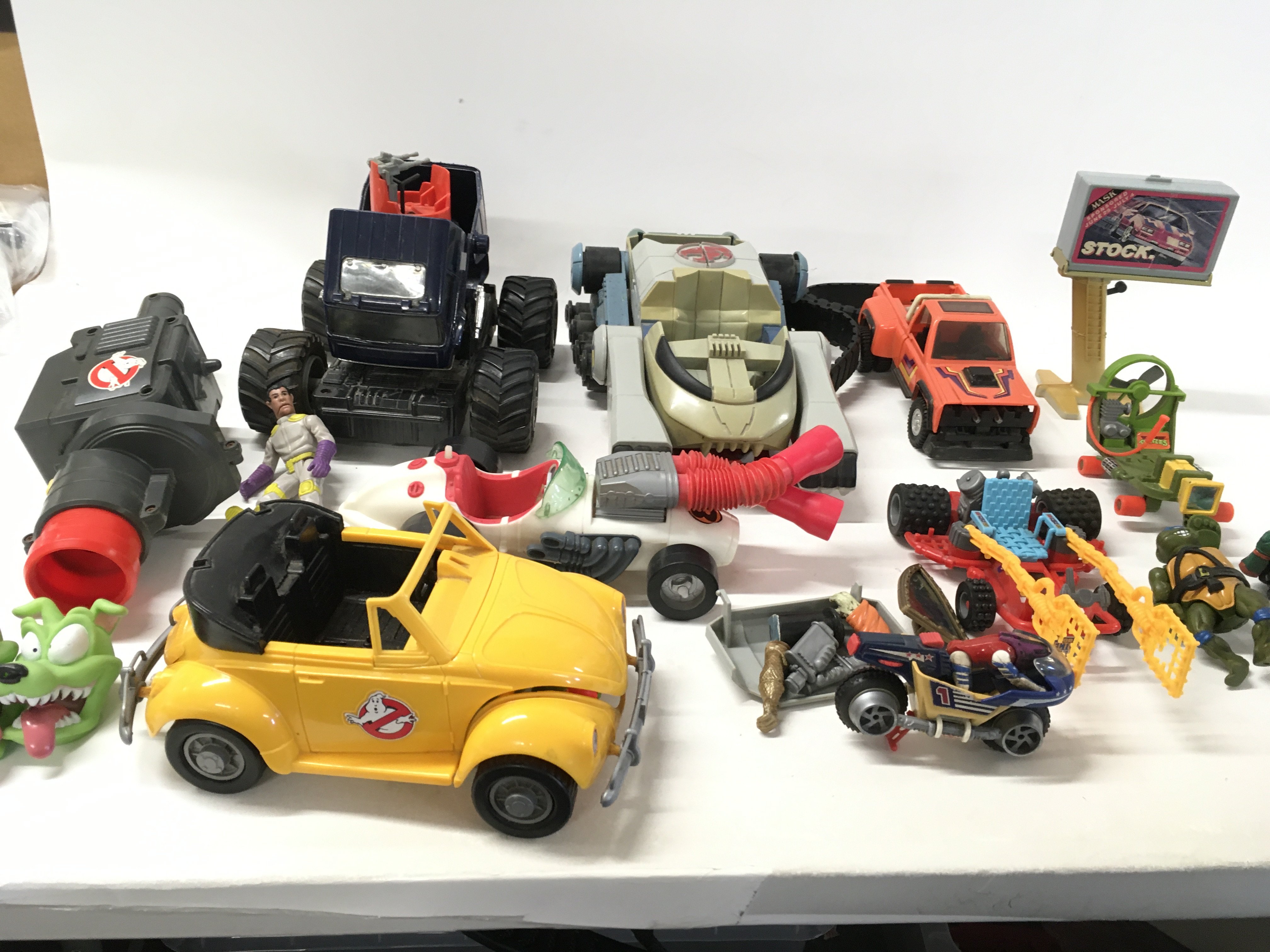 A collection of vintage vehicles ..accessories and figures from Ghostbusters..Mask..Thundercats and Turtles.