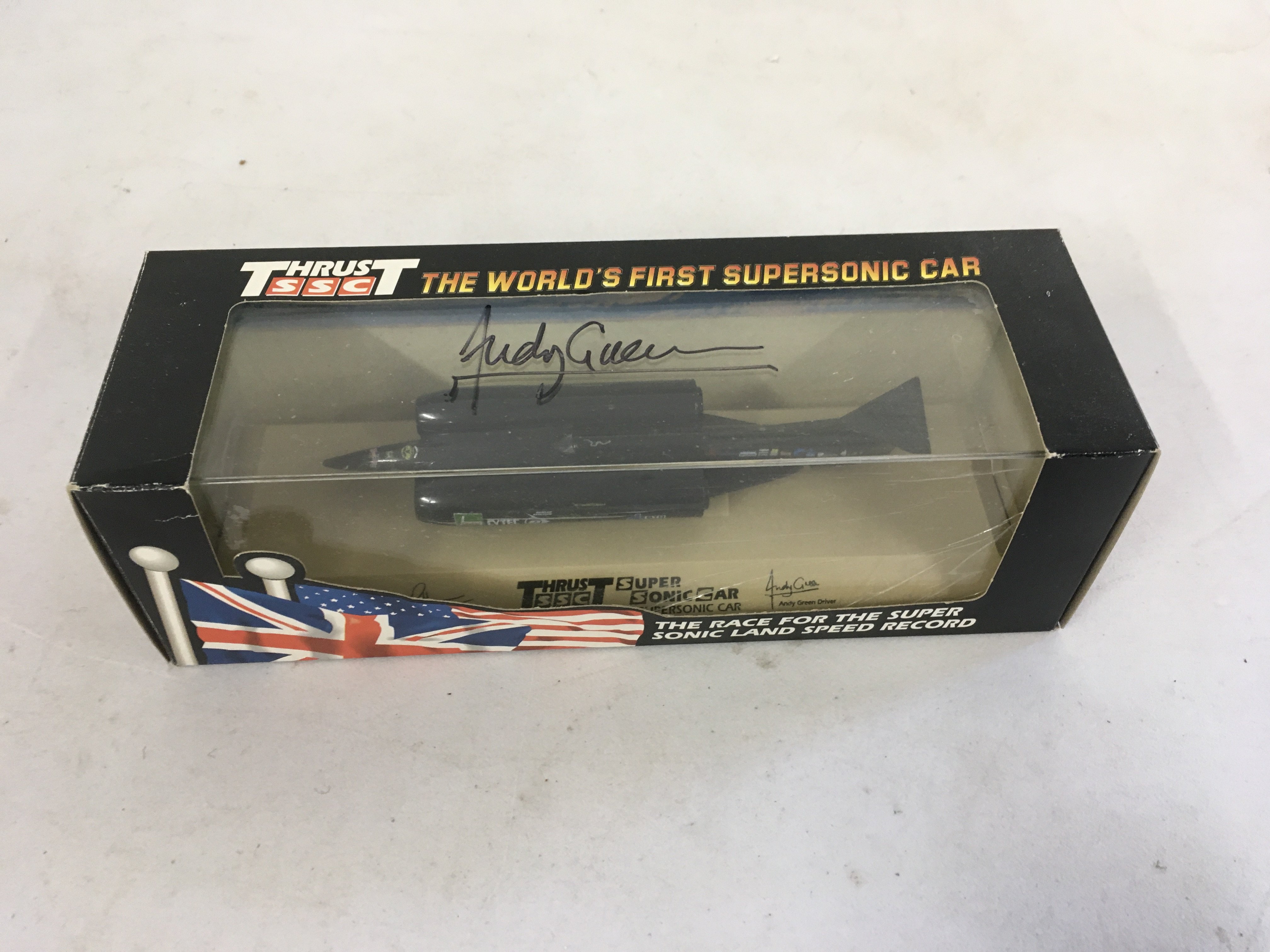 A boxed model of Thrust the worlds first supersonic car. This model has been signed by Andy Green the driver of Thrust.
