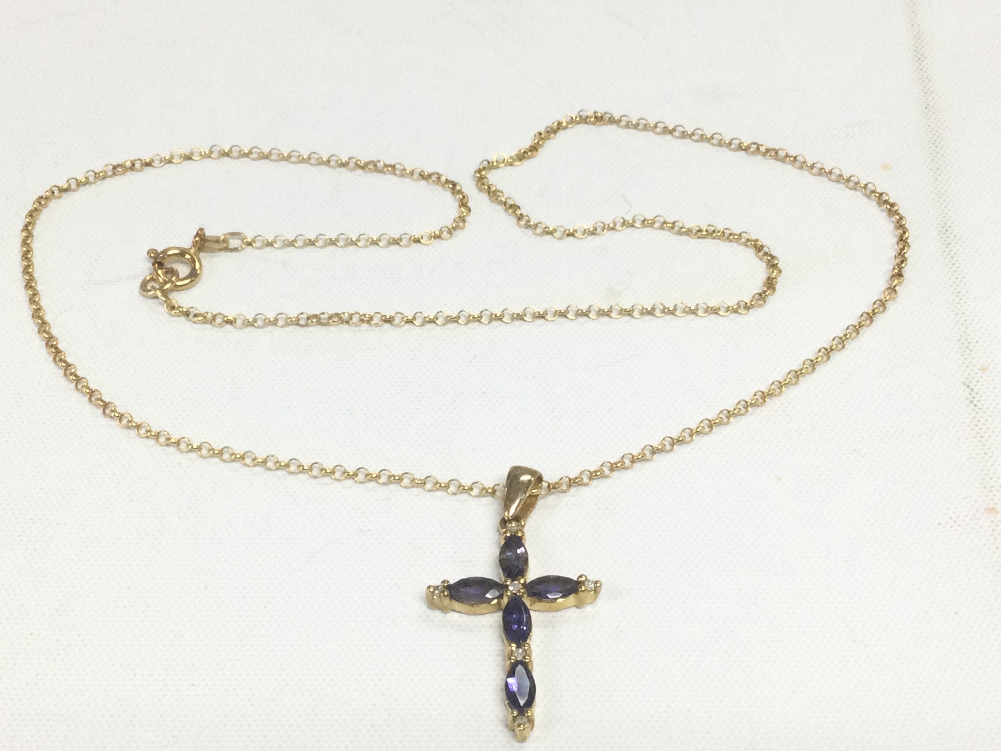 A 9ct gold cross pendant on chain set with blue stones, approx 4g. Shipping category A.