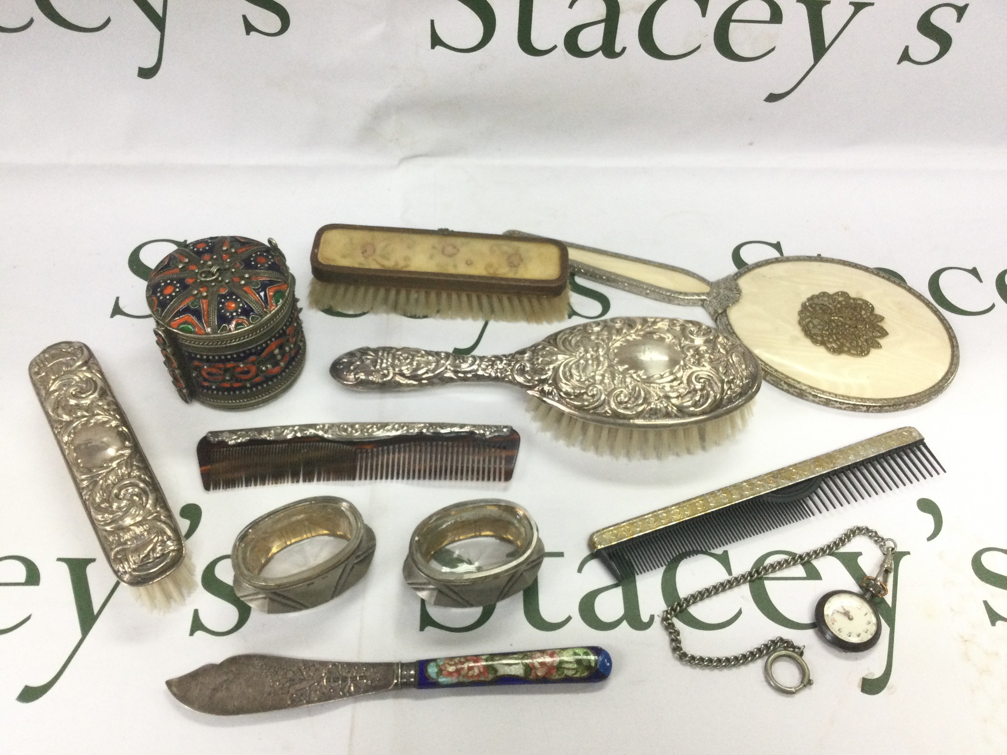 A silver backed dressing table set and one other plus a silver and enamel knife, fob watch etc. Shipping category D.