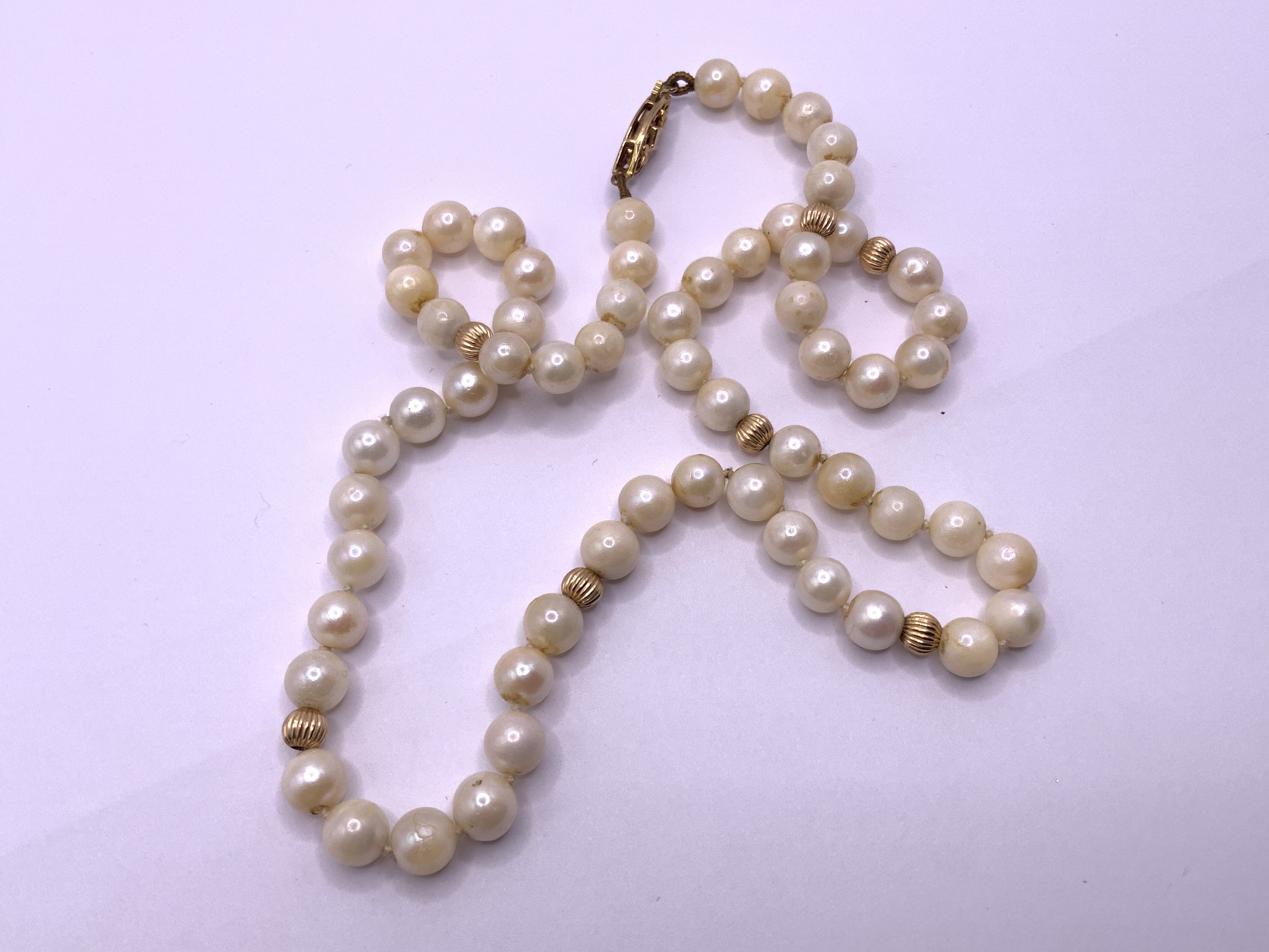 A 9ct gold and pearl necklace. (A)