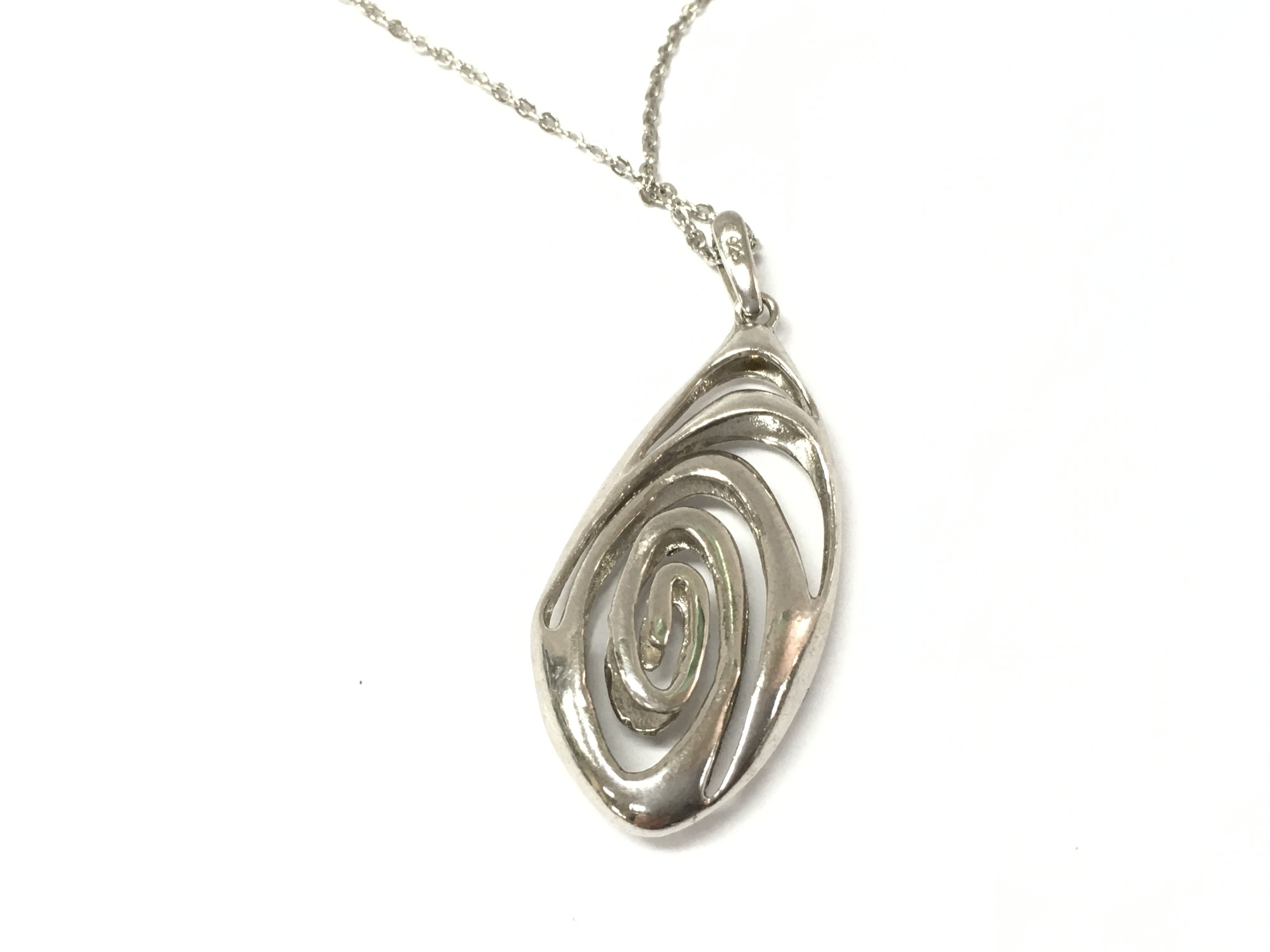 A silver swirling pendant on a silver chain. Postage A
