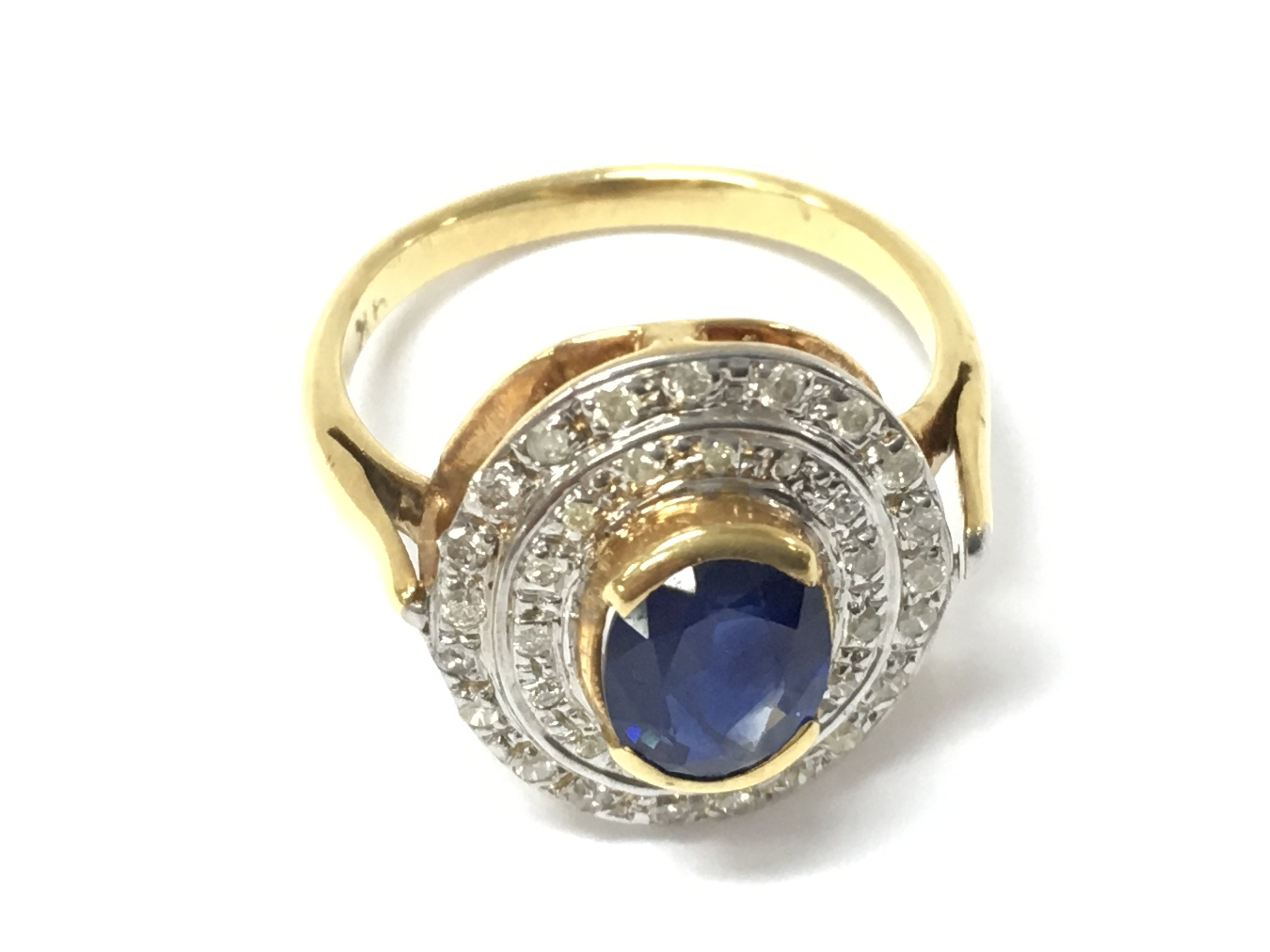 A 9ct gold oval ring semi rubber set with an oval sapphire surrounded by a double halo of diamonds. Sapphire approx 1ct and diamonds 0.40ct Approx. Size M 1/2