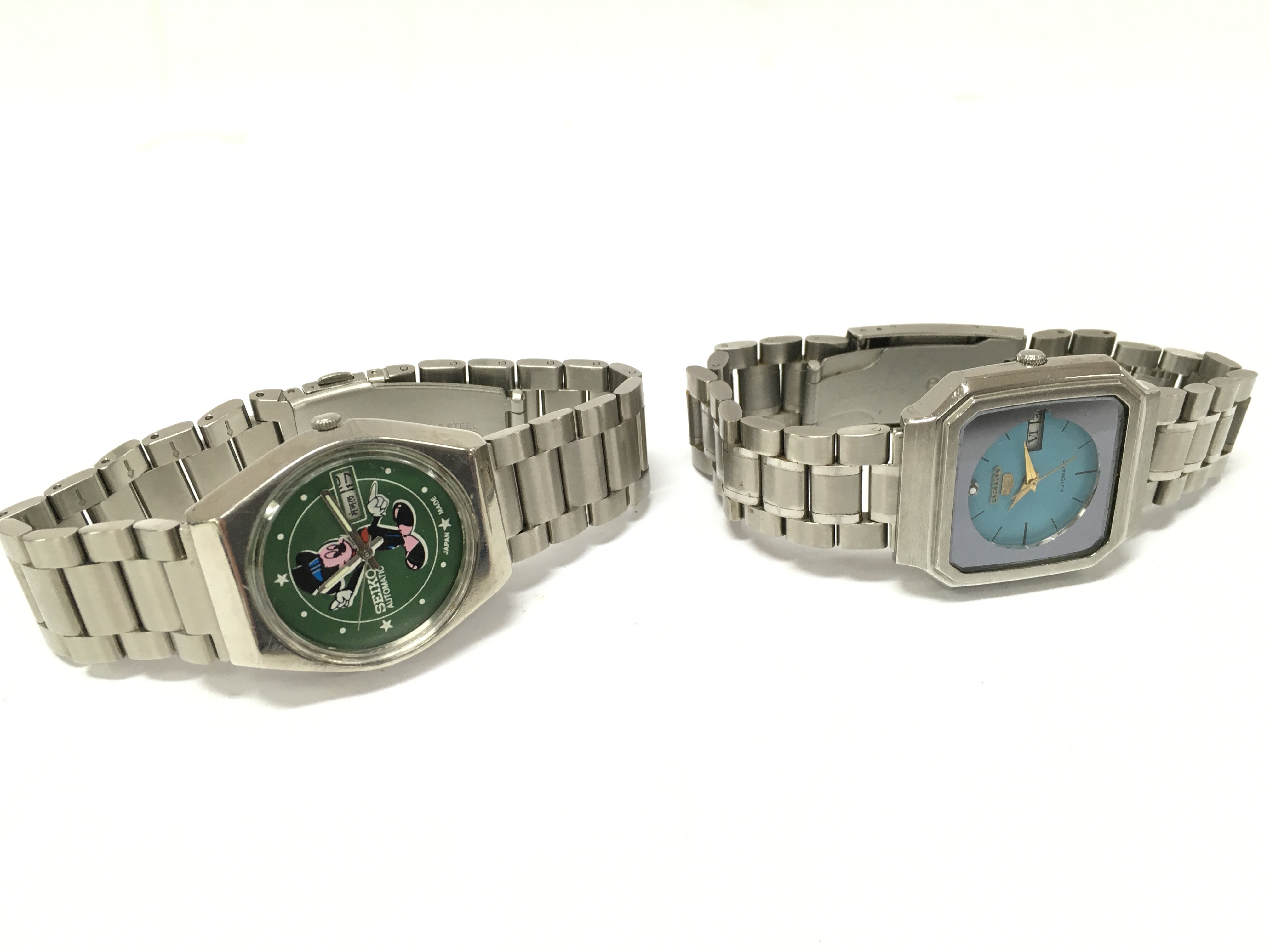 Watches including Seiko 5 automatic Arabic day/date, vintage Seiko 5 green face, Rone Gents wrist watch, Vintage Seiko Emerald green TV dial and a Seiko Automatic Mikey Mouse face Japan made watch. Stored in a watch case. Postage category B
