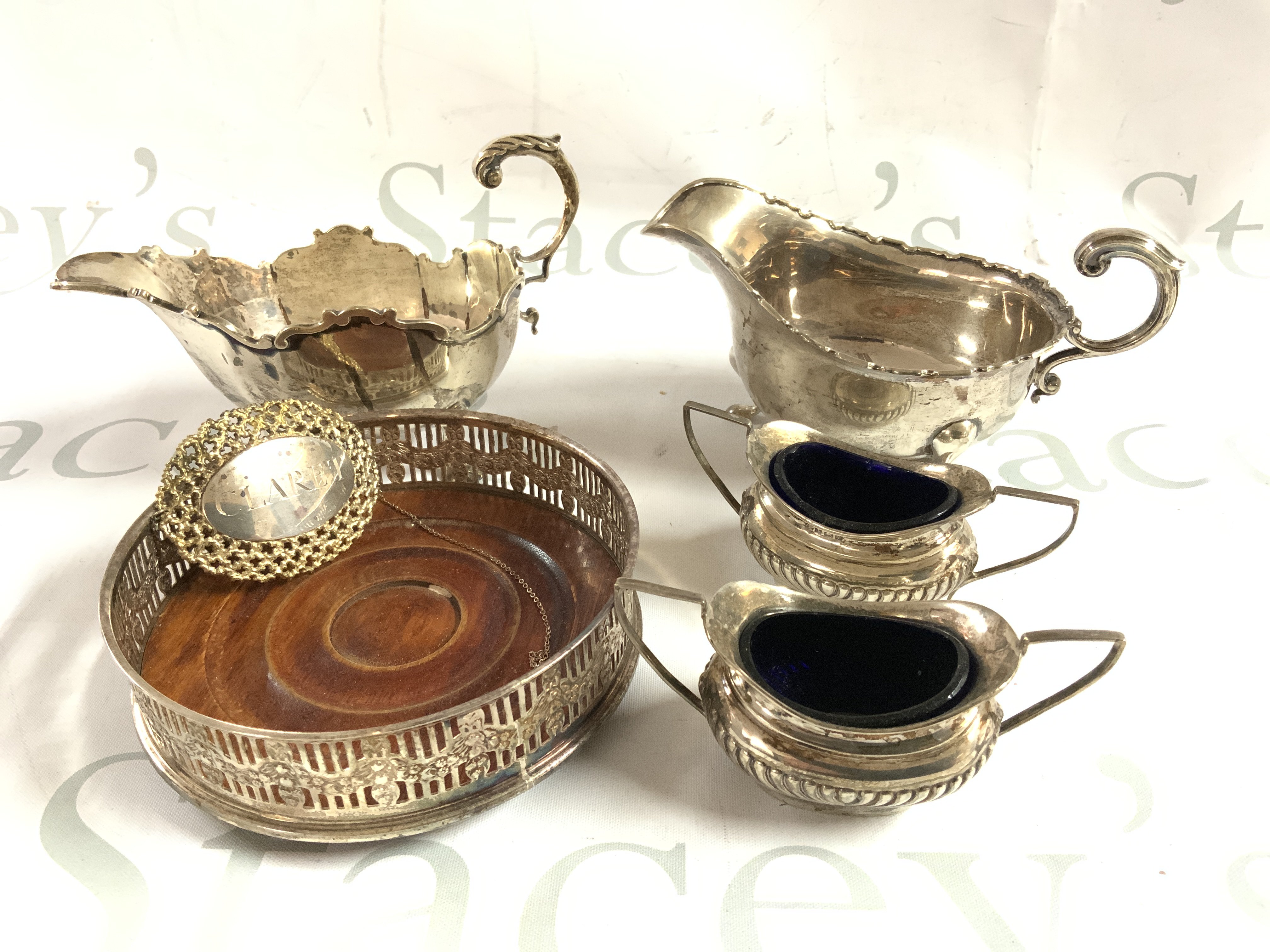 2 hallmarked silver gravy boats, Hallmarked silver bottle coaster, Claret wine label, hallmarked silver salts. (A)