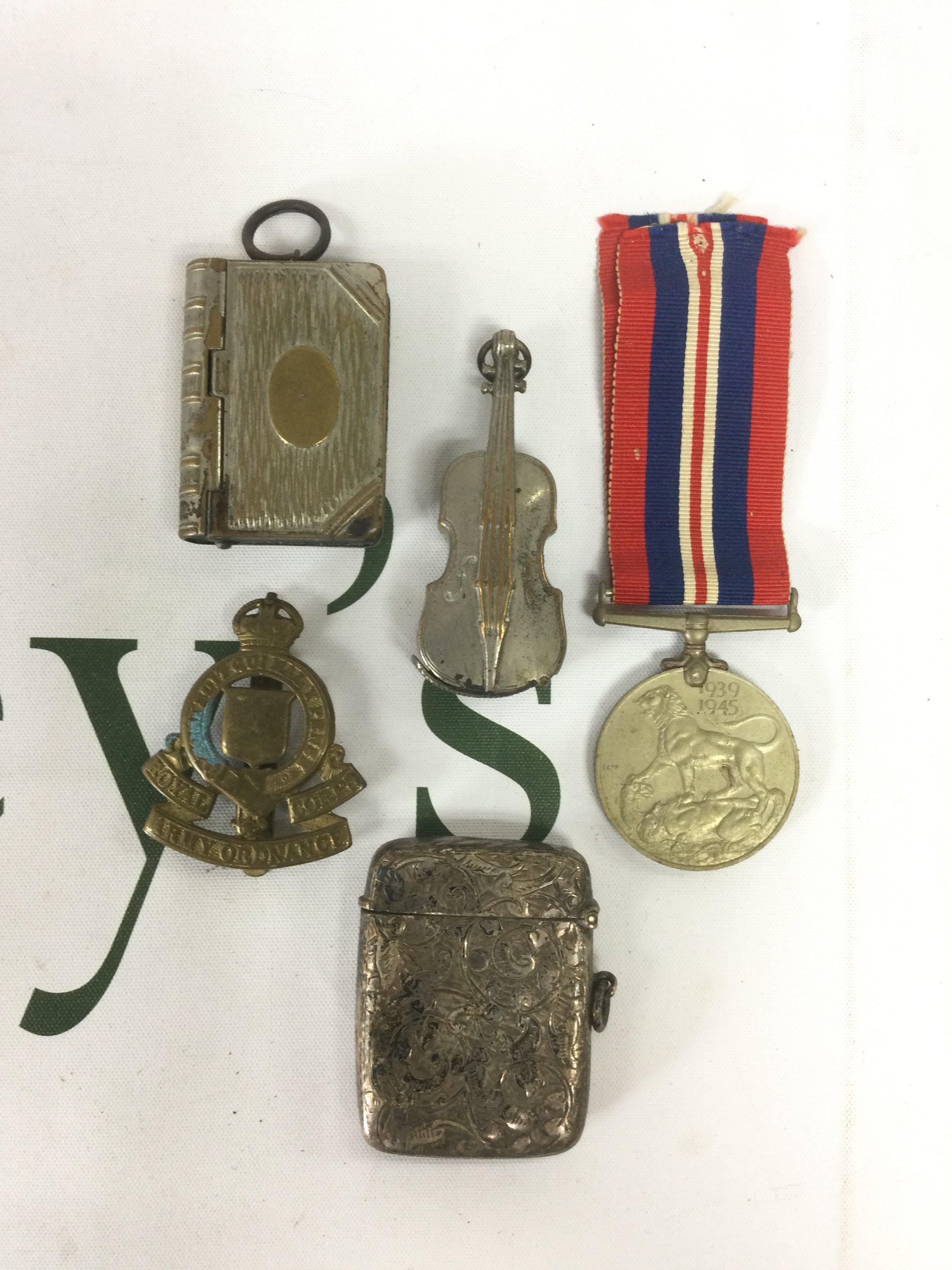 Three vesta cases, a WW2 service medal and a cap badge. Shipping category A.