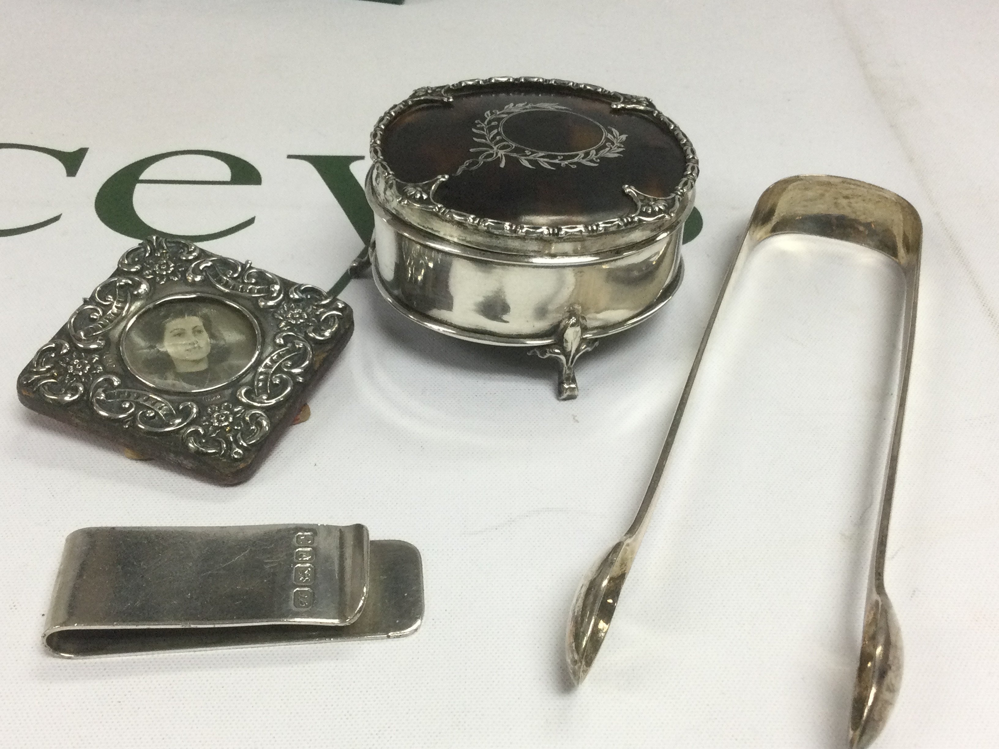 Four silver items comprising a small photo frame, circular box etc. Shipping category B.