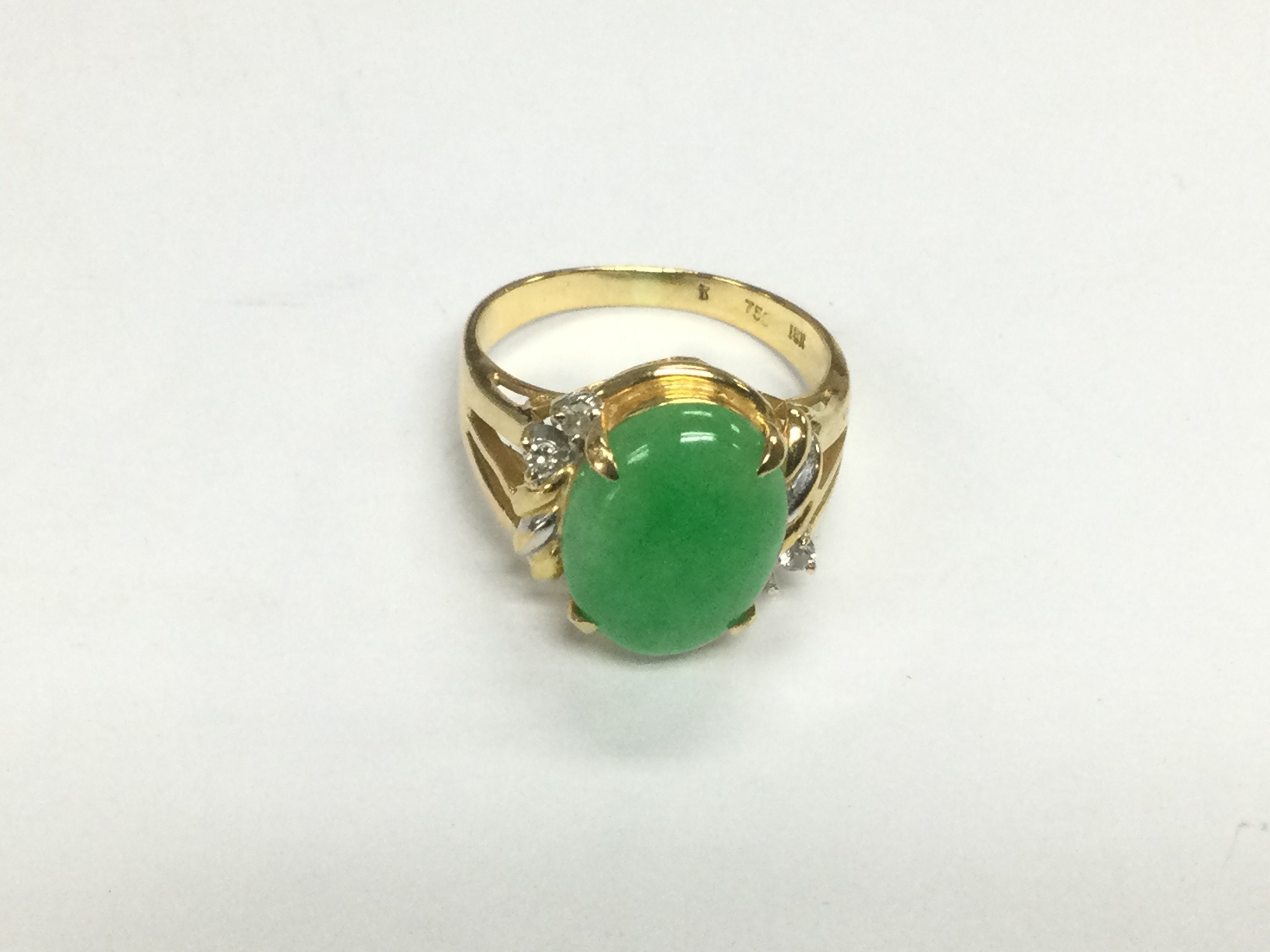 An 18ct gold ring set with a green jade cabuchon stone, approx 6.3g and approx size O-P. Shipping category A.