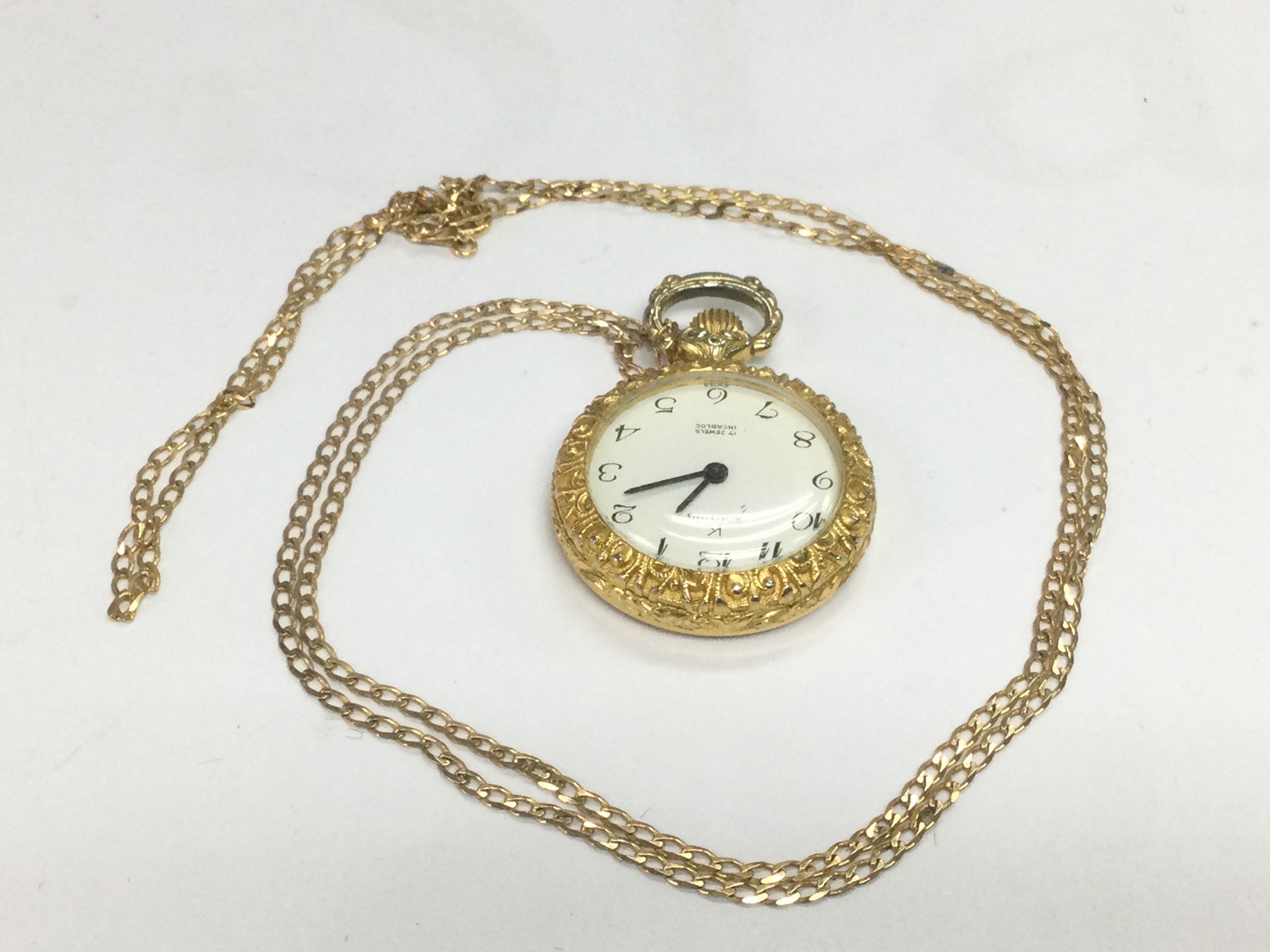 A fob watch suspended on a 9ct gold chain. Shipping cateory A.