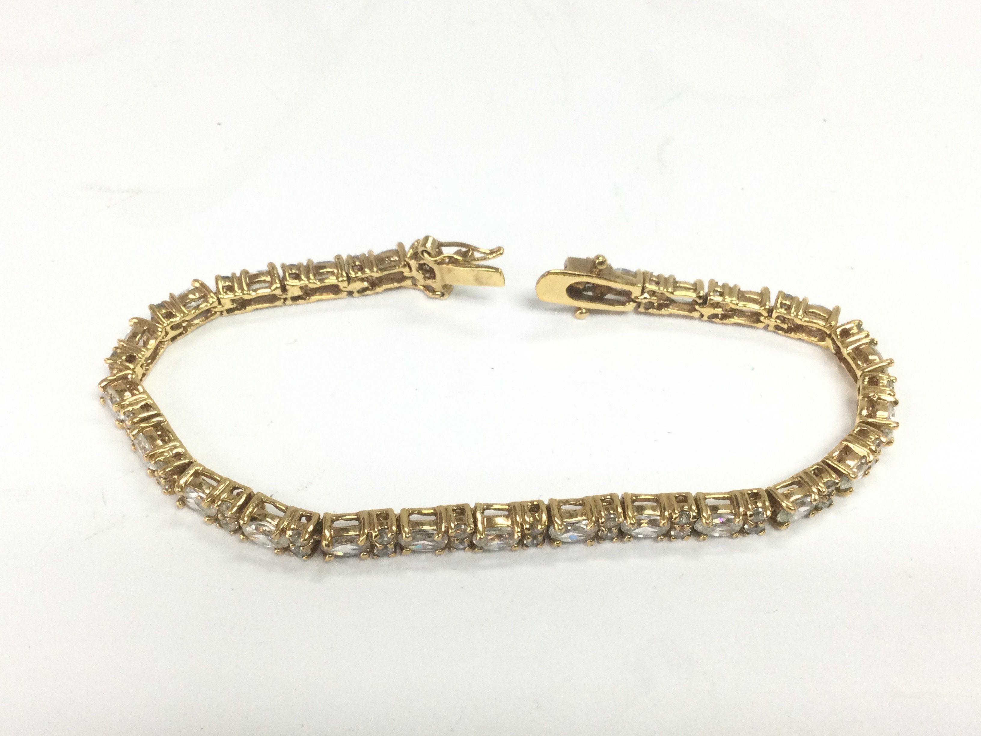A yellow metal bracelet set with CZs. Shipping category A.