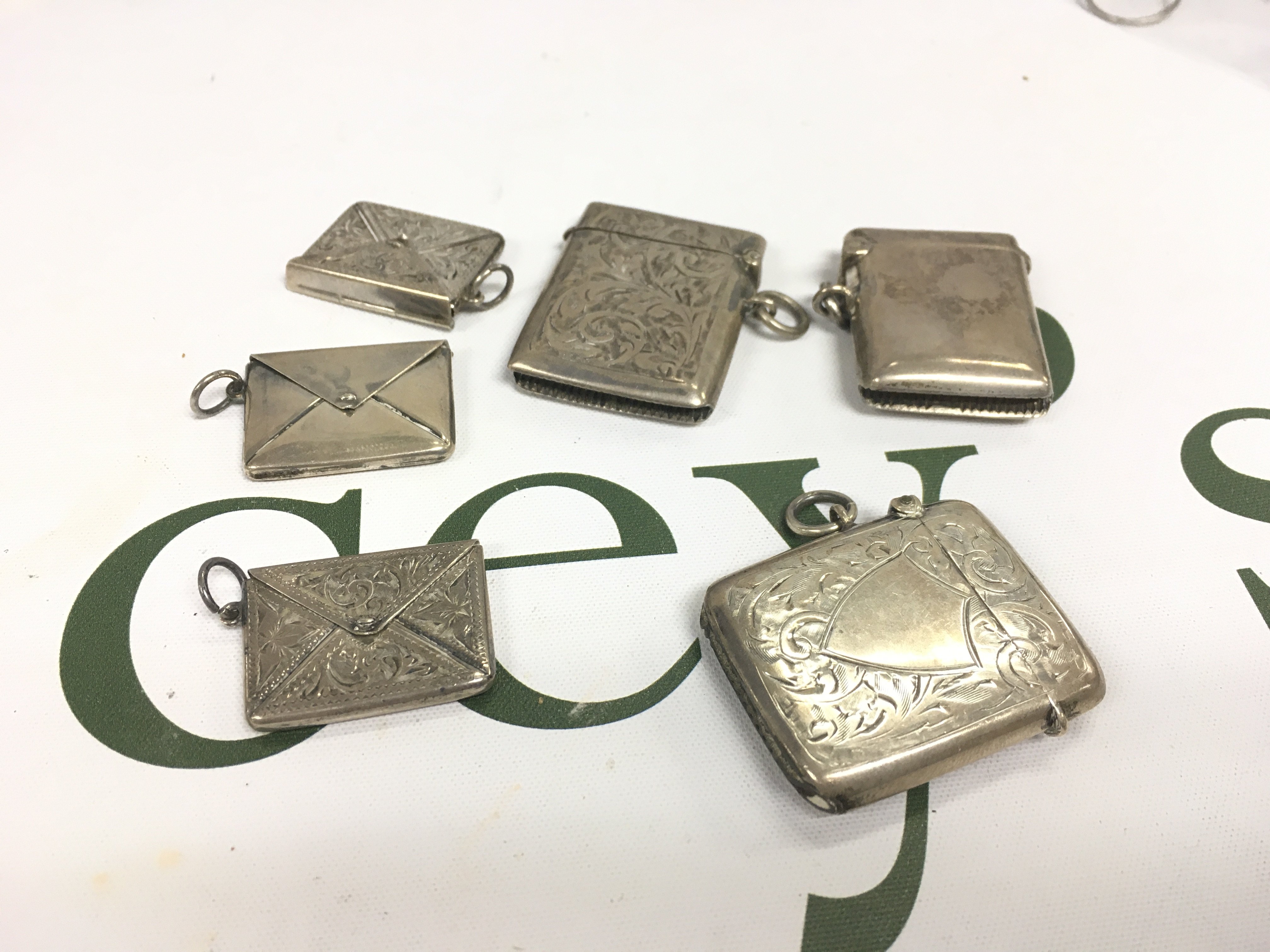 Three silver vesta cases and three silver stamp cases.
