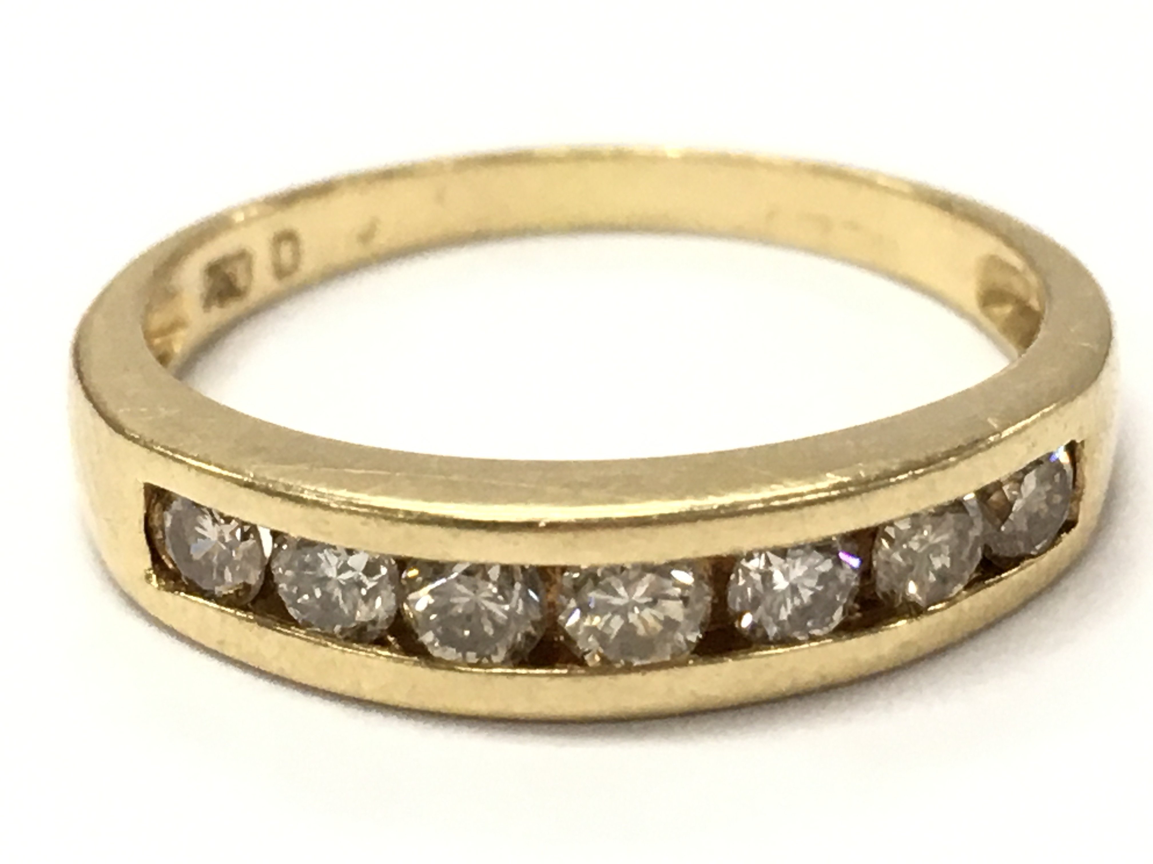 An 18ct gold Channel set diamond 1/2 hoop ring. 3.2g total weight. N/O. Postage category A