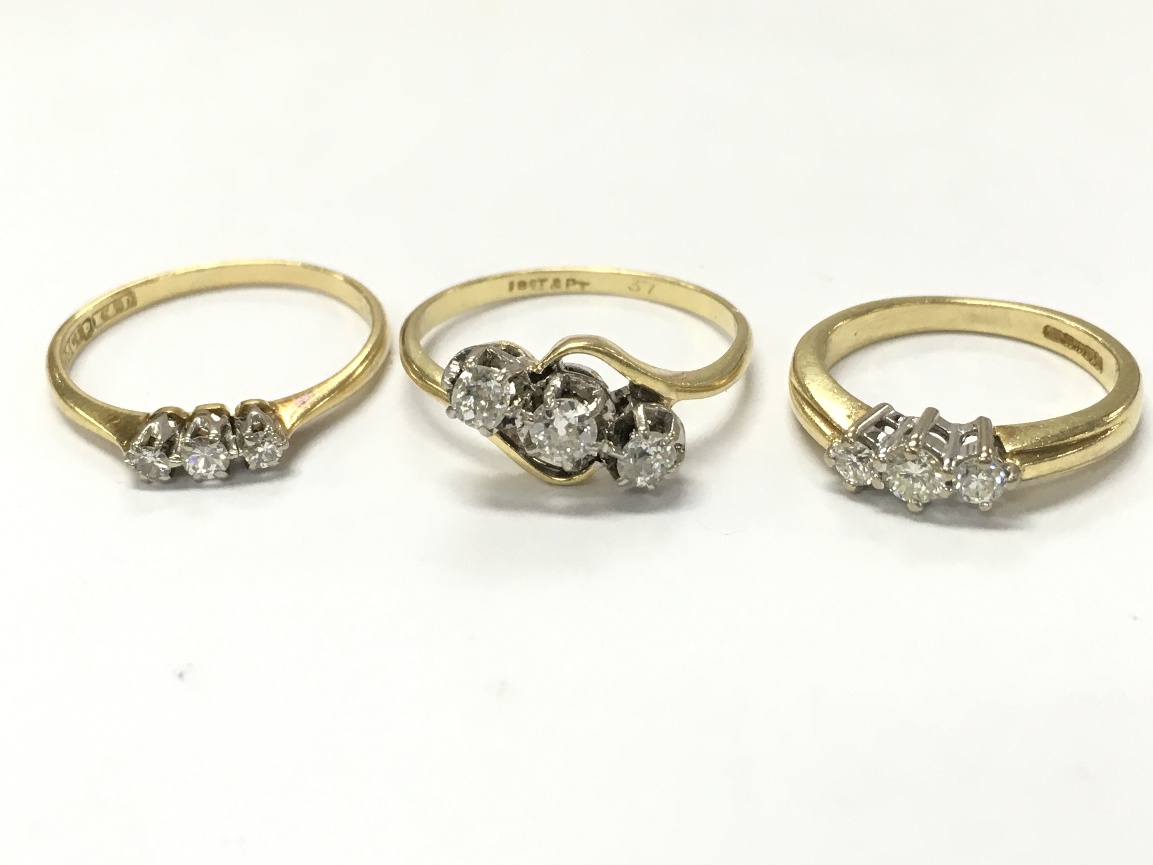 18ct gold three stone diamond rings , 7.7g total weight. Postage category A