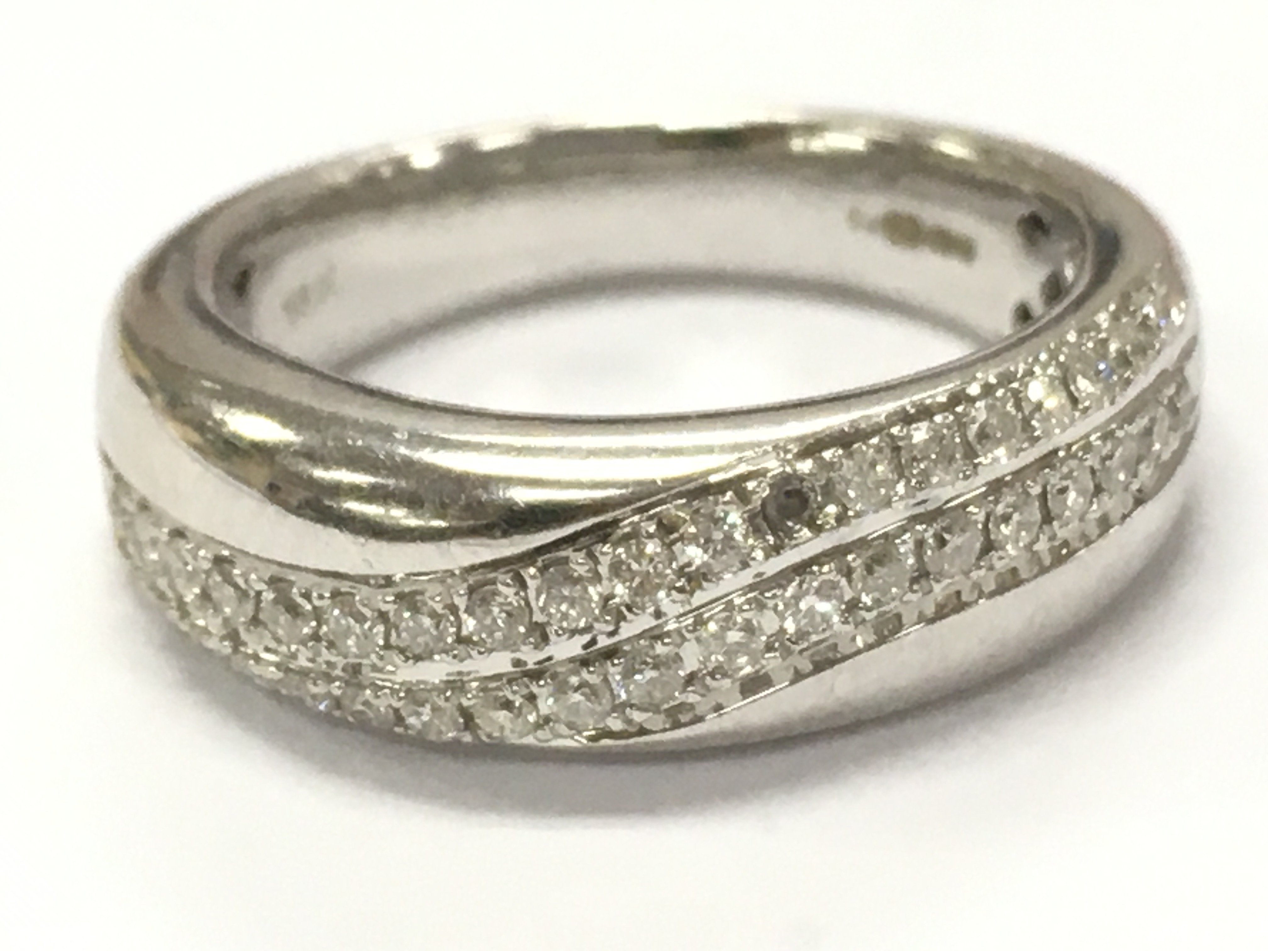 An 18ct white gold diamond band ring, 5.6g total weight. Size K/L. Postage cat A