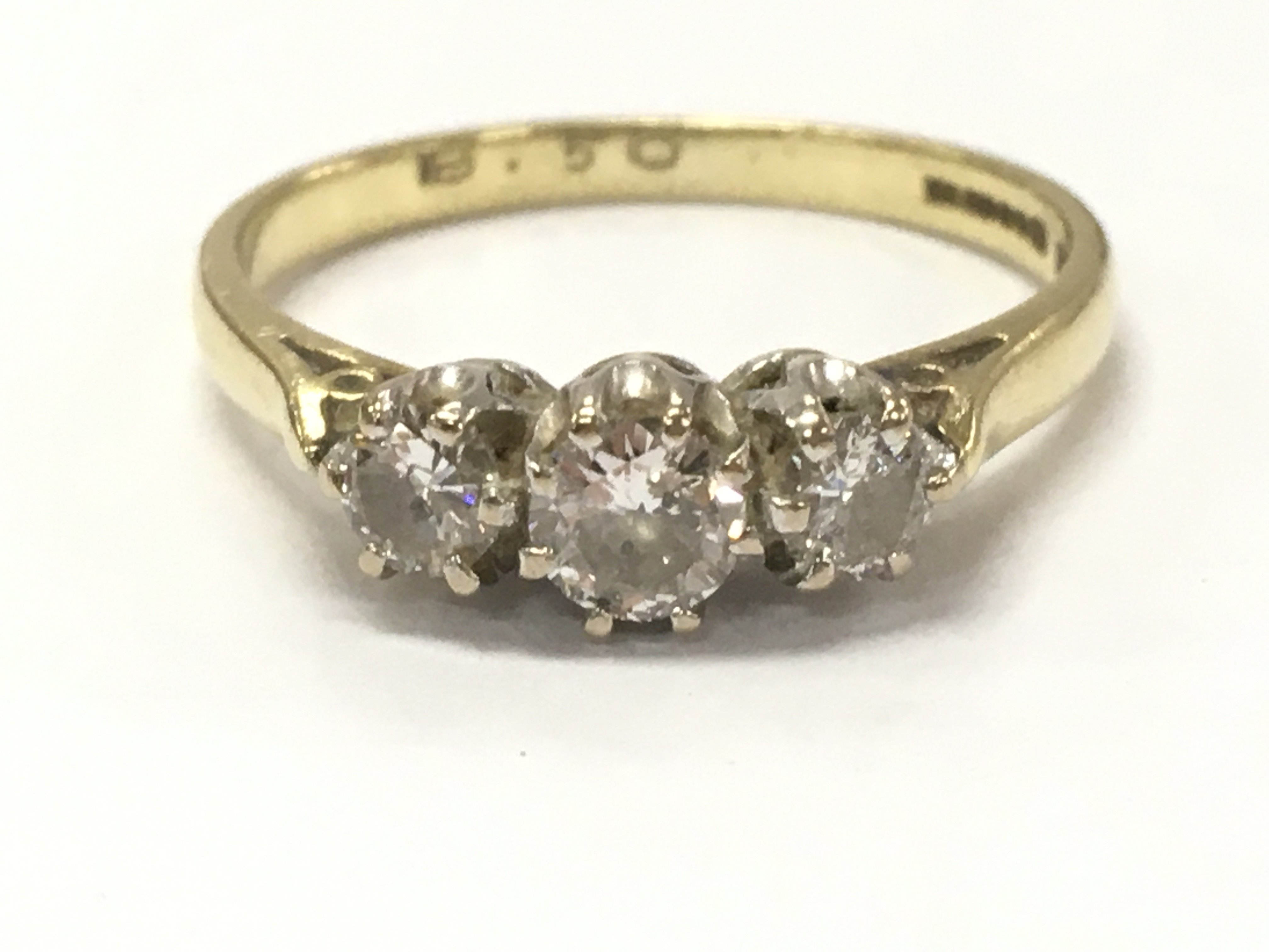 An 18ct gold three stone diamond ring, 2.4g total weight, size N. Postage category A