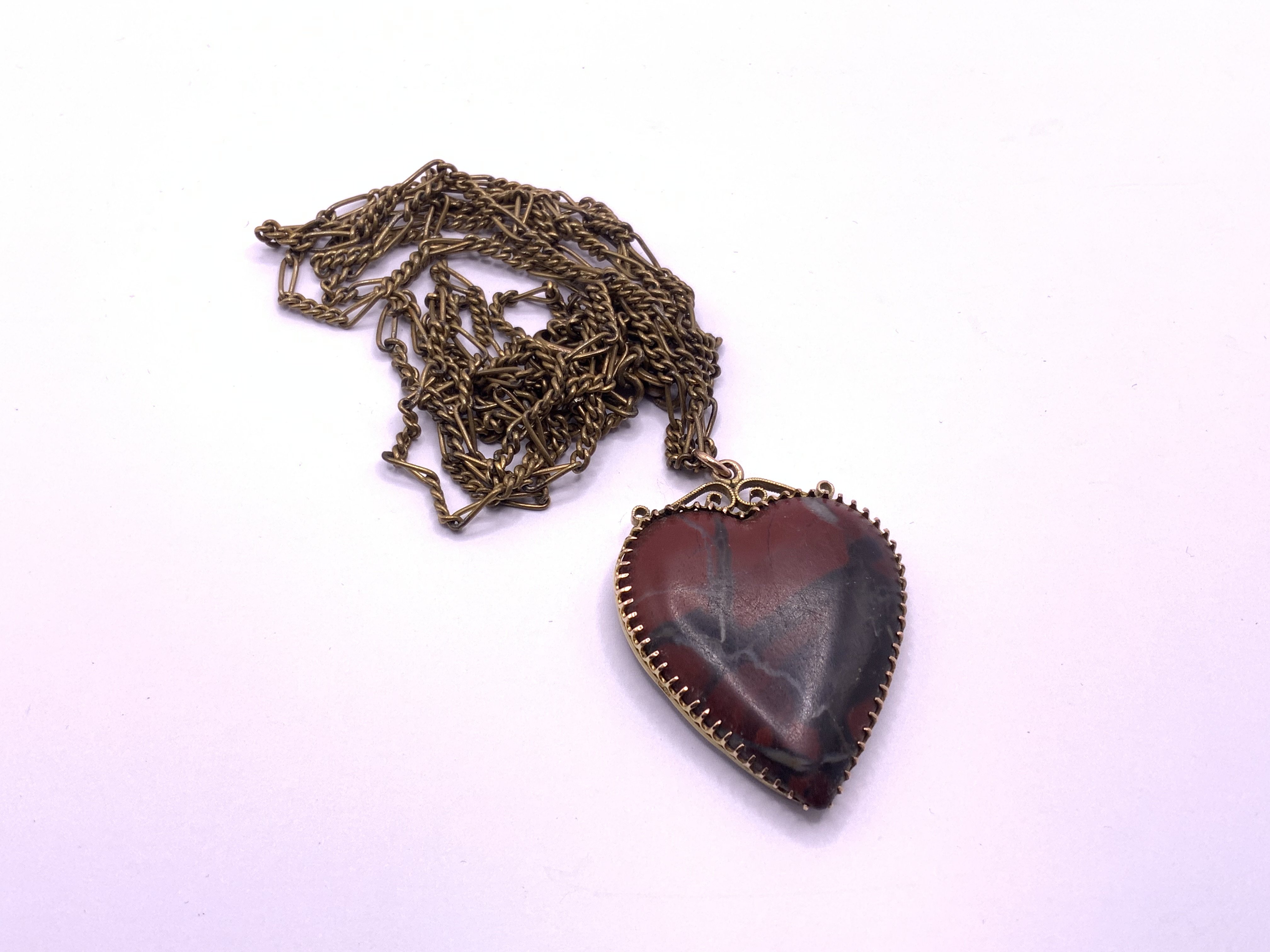 A Victorian Scottish 9ct gold mounted heart pendant with a gold plated chain. (A)