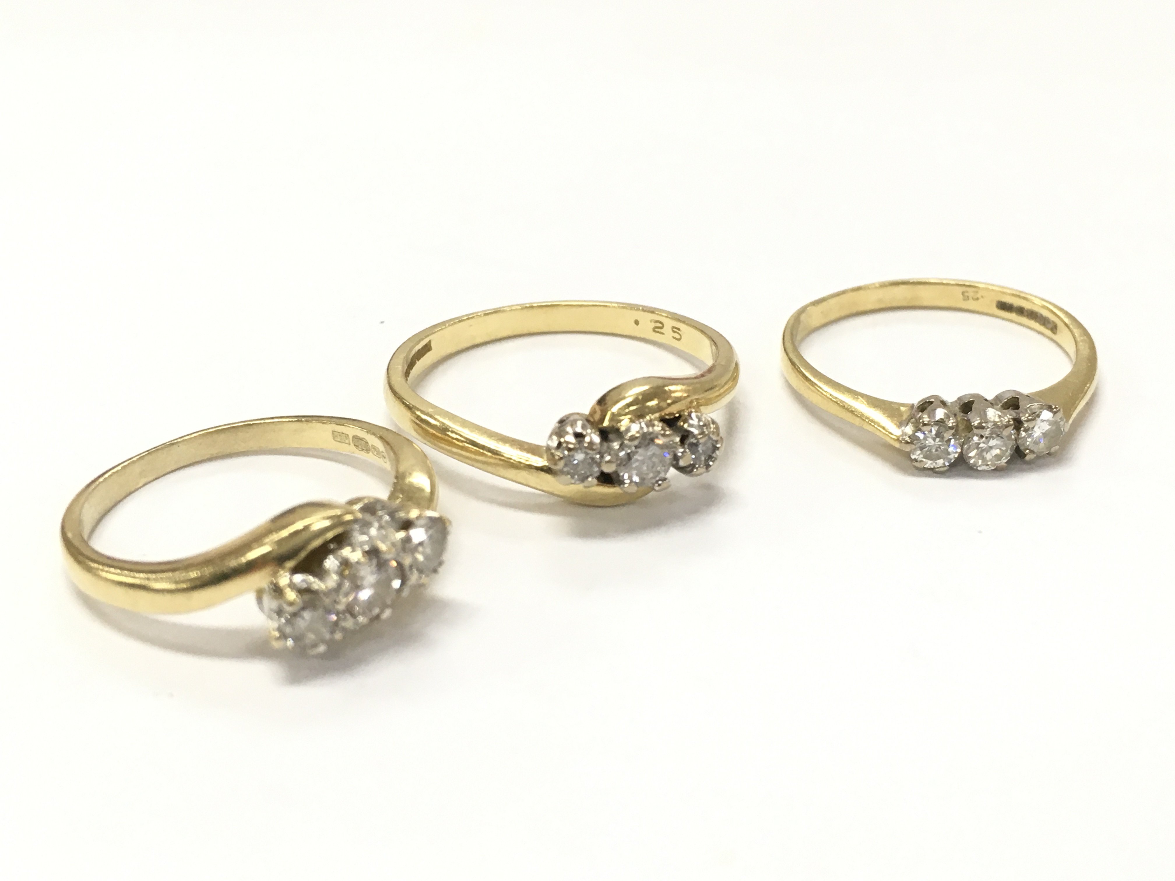 18ct gold three stone diamond rings . Sizes J,K,P 9g total weight. Postage category A