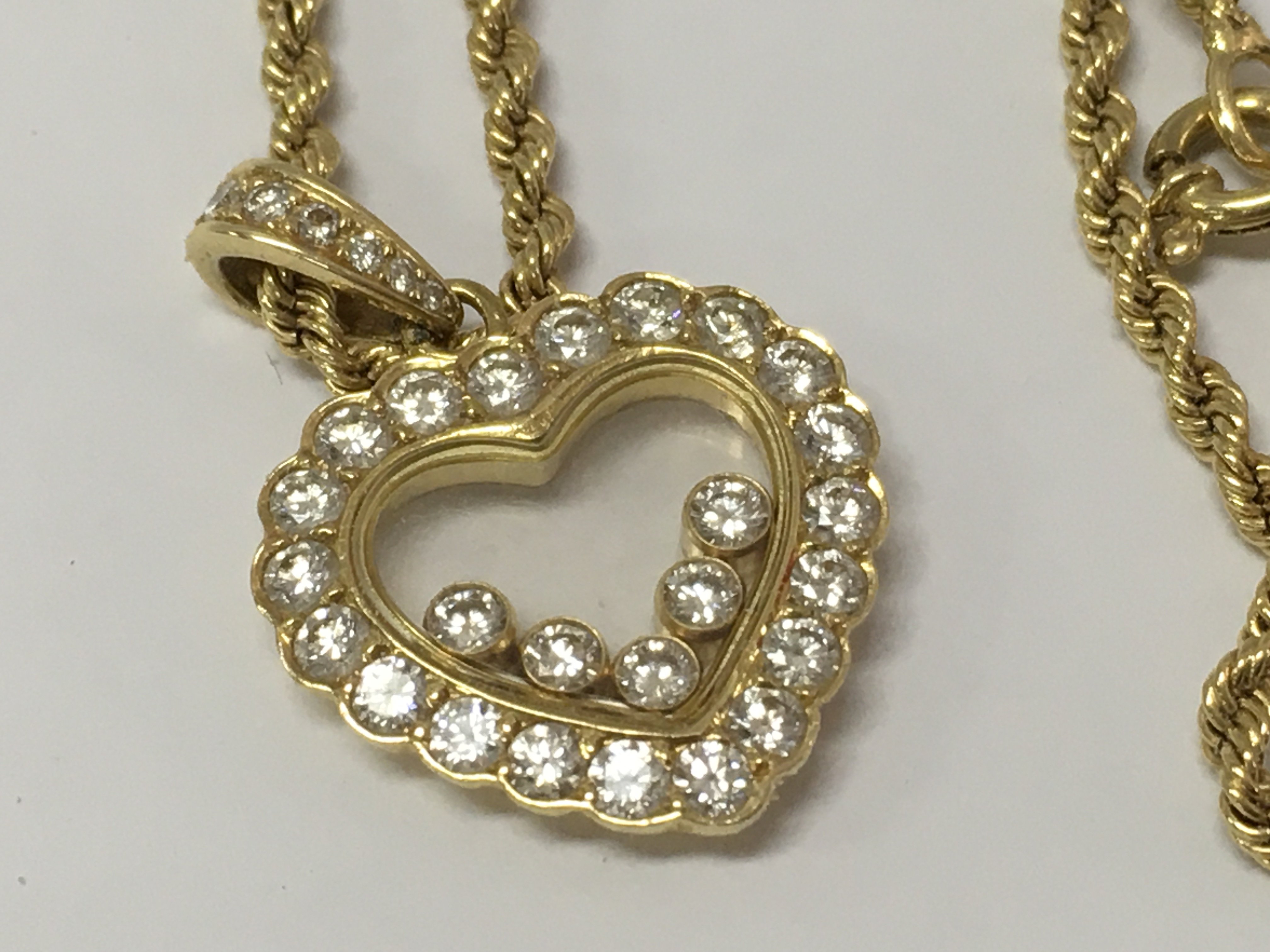 A Chopard Happy diamond 18ct yellow gold heart pendant, the frame inset with five floating round cut brilliant diamonds with attached rope chain .fitted in original box .
