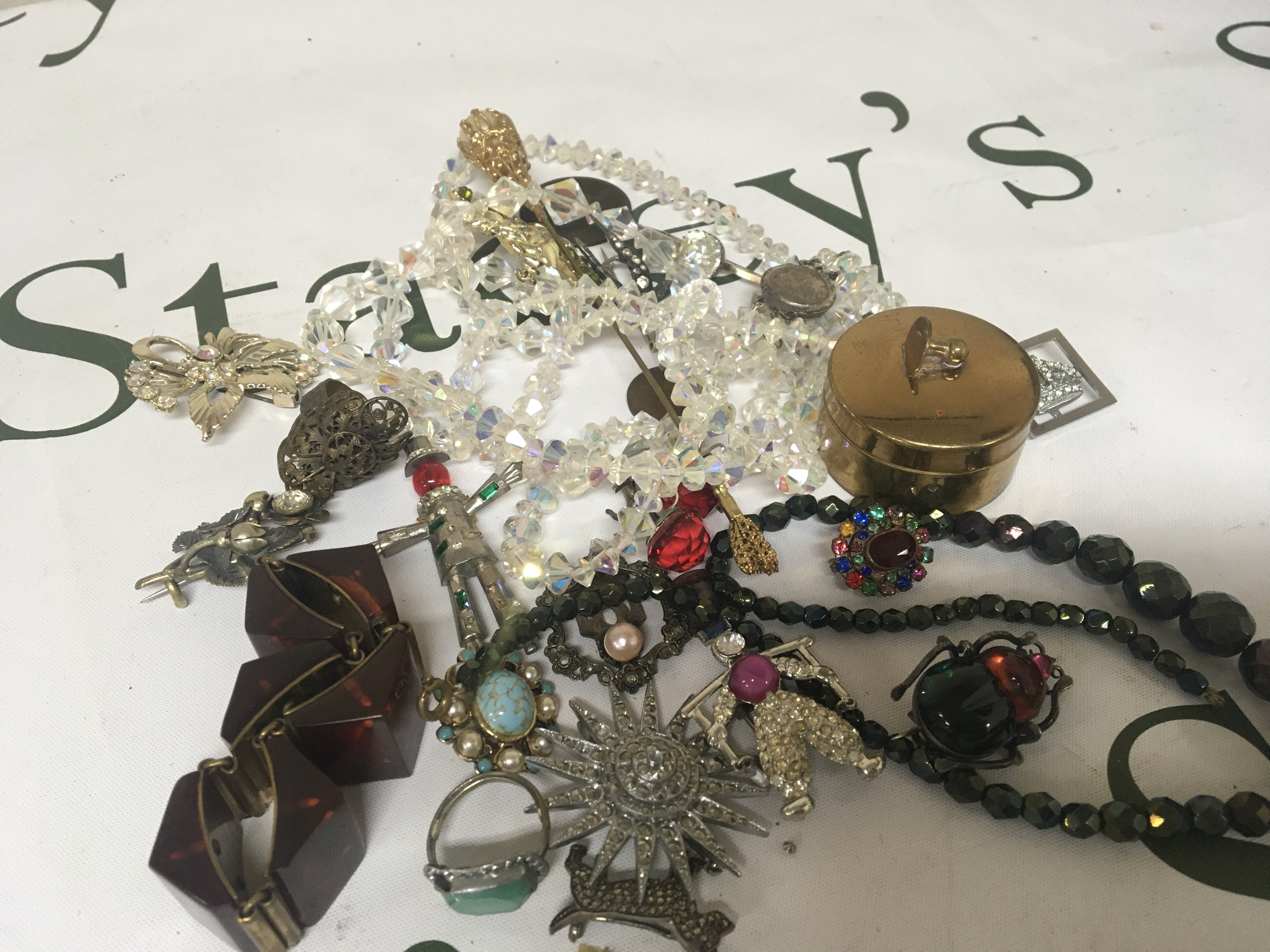 A collection of costume jewellery including a Beatle brooch and other brooches rings and oddments.