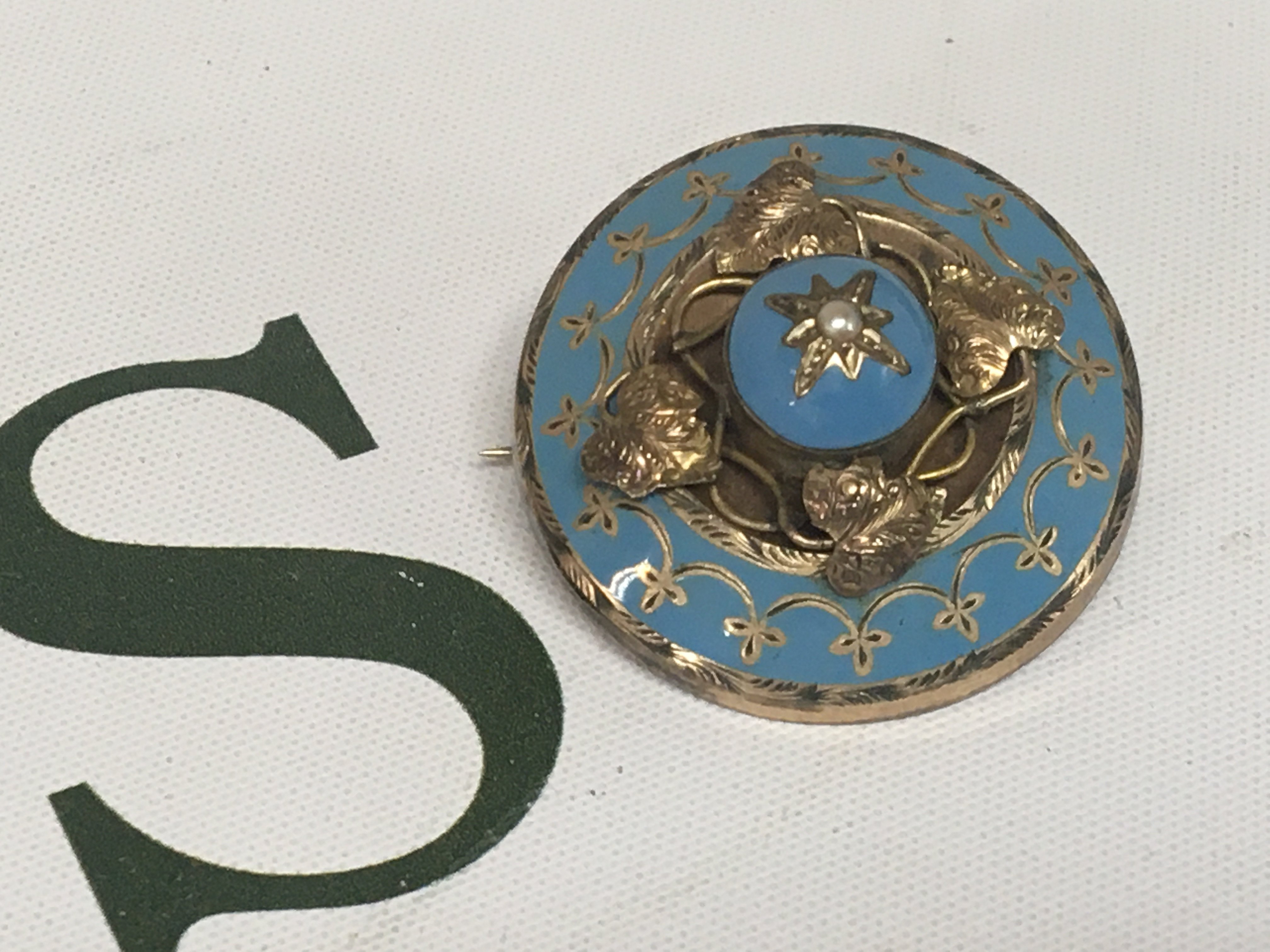 An Antique gold and pale blue enamel mourning brooch of oval shape with a central seed pearl. Unmarked.