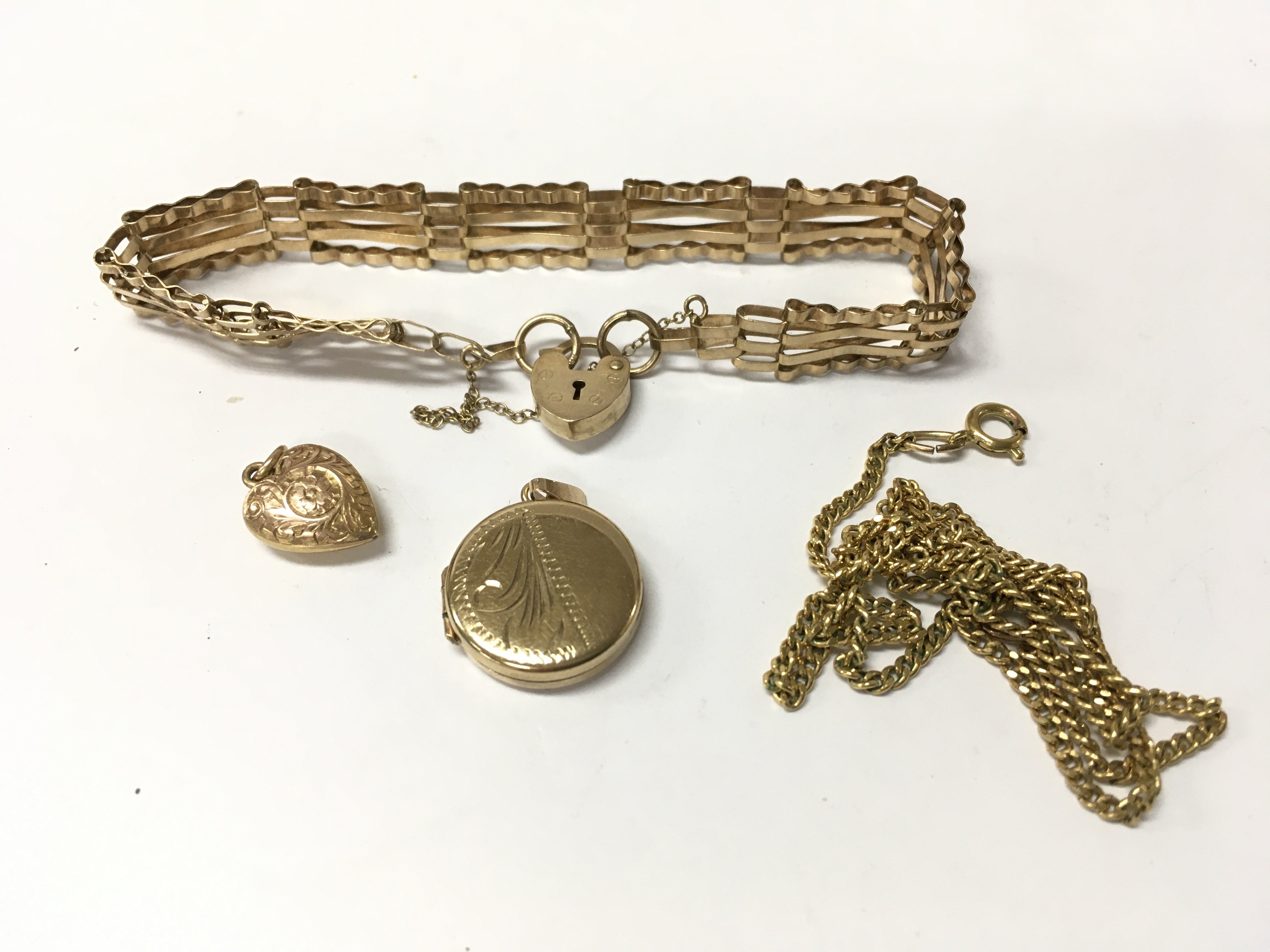 A 9ct gold gate bracelet with a yellow metal chain and two gold pendants. Approx weight 10 grams.