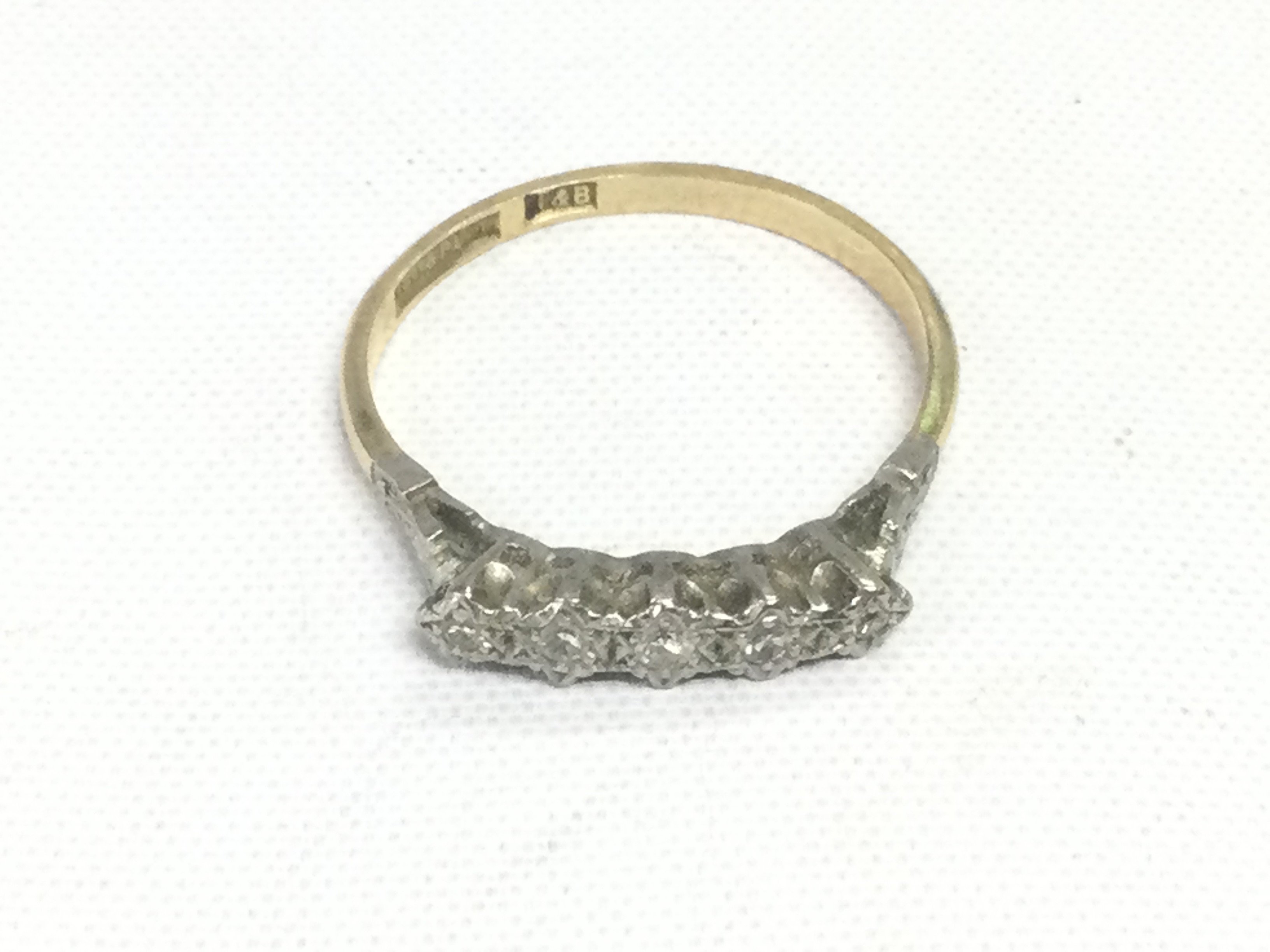 An 18ct gold and platinum ring set with five small diamonds, approx 2.6g and approx size S-T. Shipping category A.