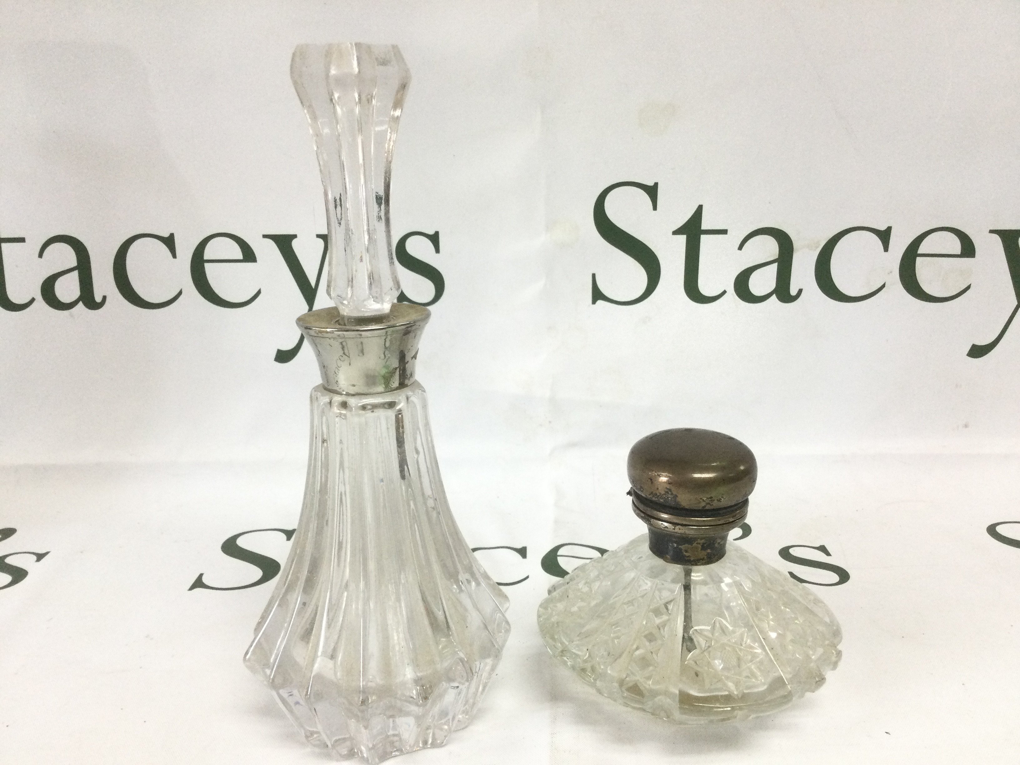 A silver topped perfume bottle plus one other. Shipping category D.