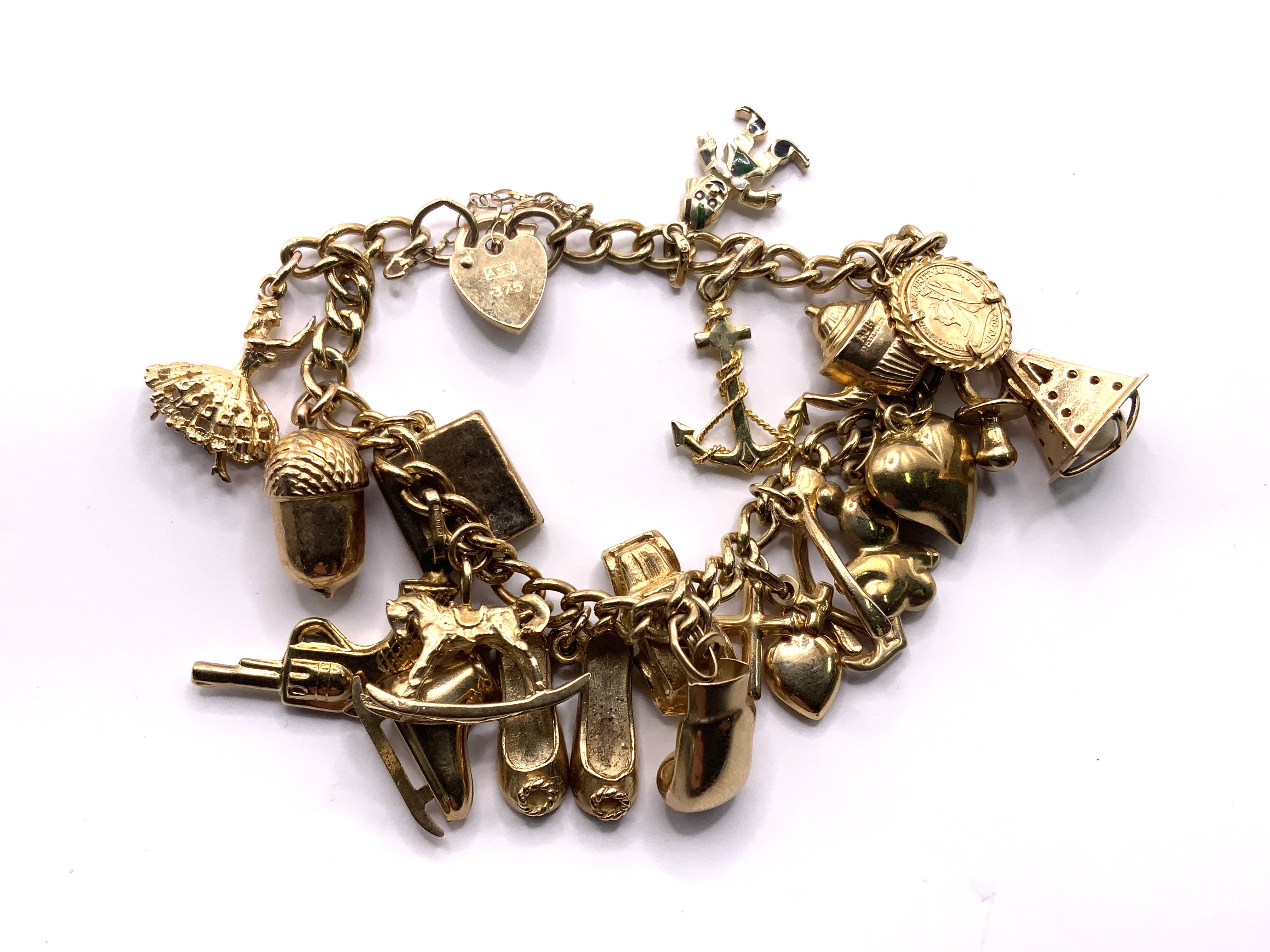 A heavy 9ct gold multi charm bracelet. 34.04gs (A)