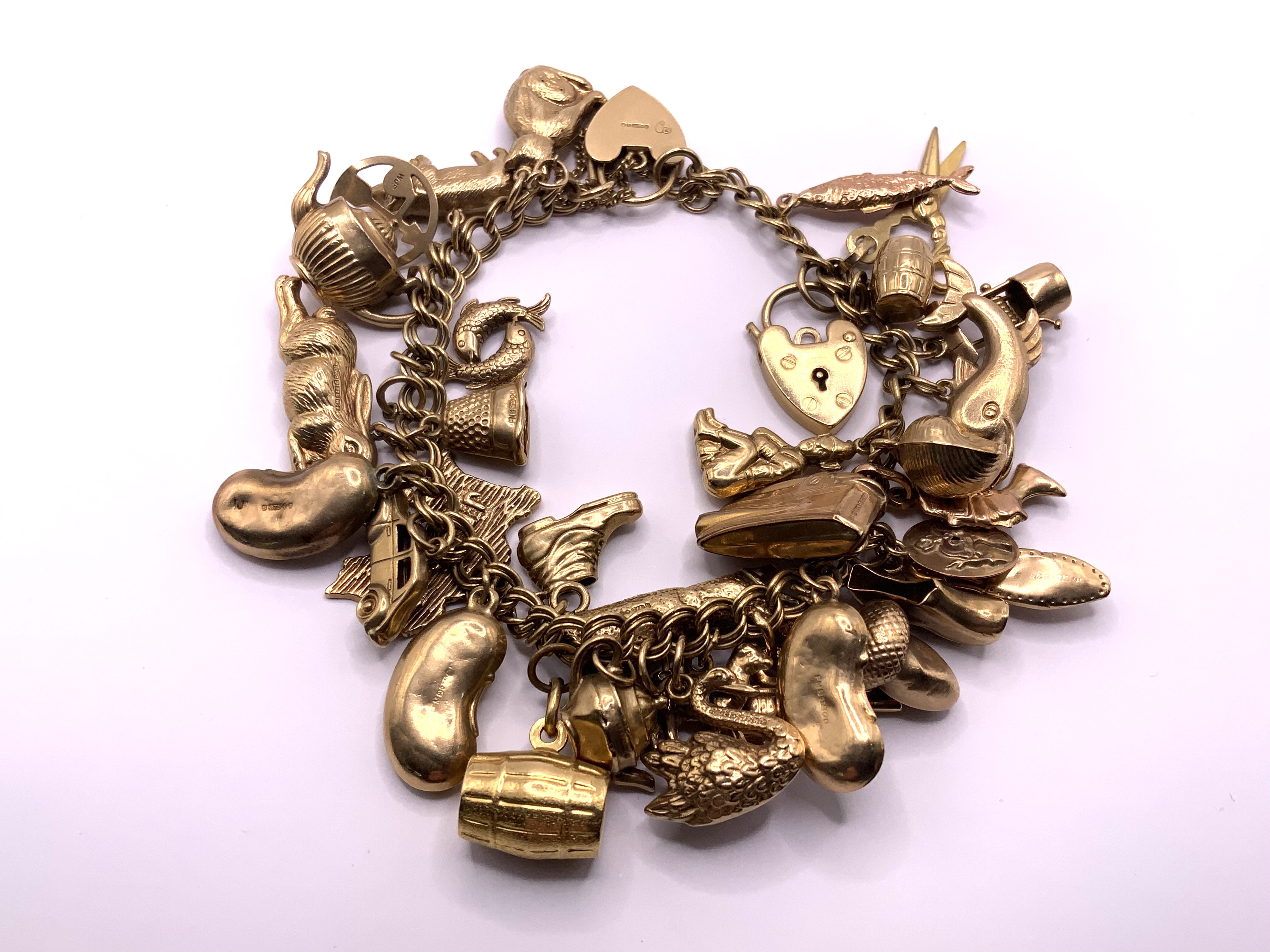 A heavy 9ct gold multi charm bracelet. 46.3gs (A)