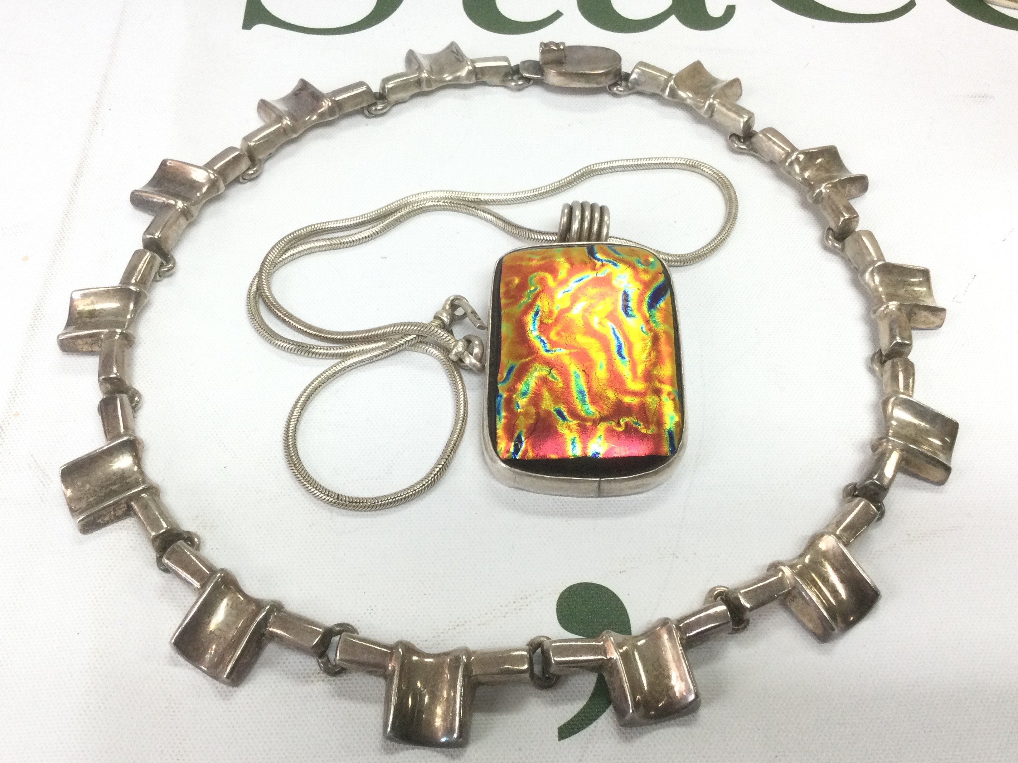 A silver choker necklace and a coloured glass pendant on chain (2). Shipping category A.