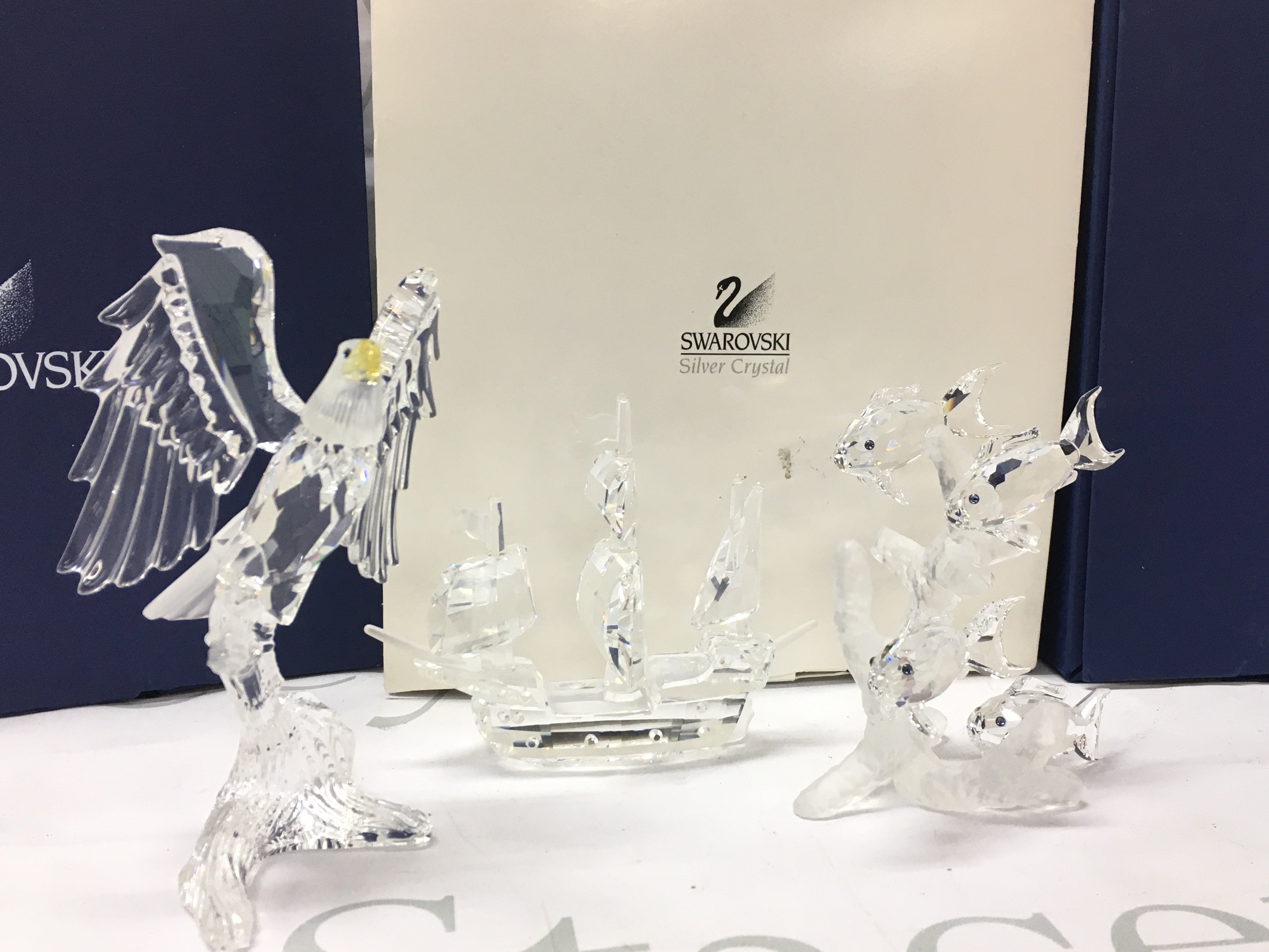 Boxed Swarovski Crystal glass figures including bald eagle, Santa Maria ship, tropical fish group (one fish loose). Postage category C