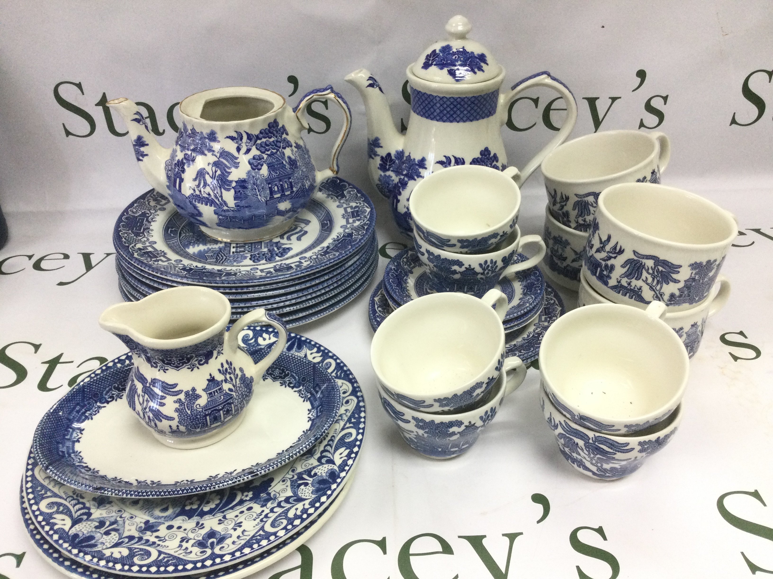 A collection of blue and white tableware comprising mainly Old Willow pattern examples. Shipping category D.