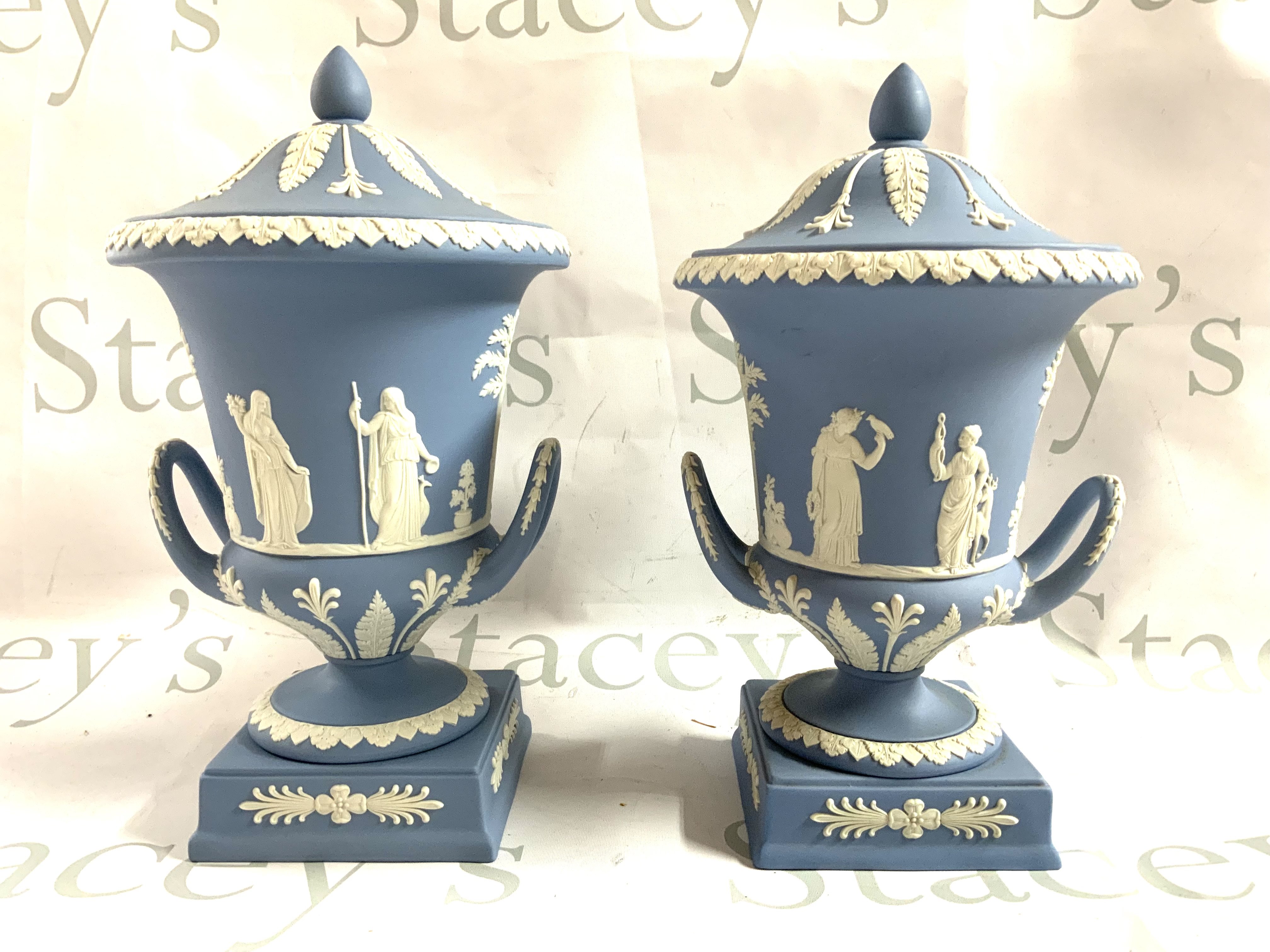2 Wedgewood Jasperware urns and covers with classical scenes. 31cm/30cm. (68/84) (D)