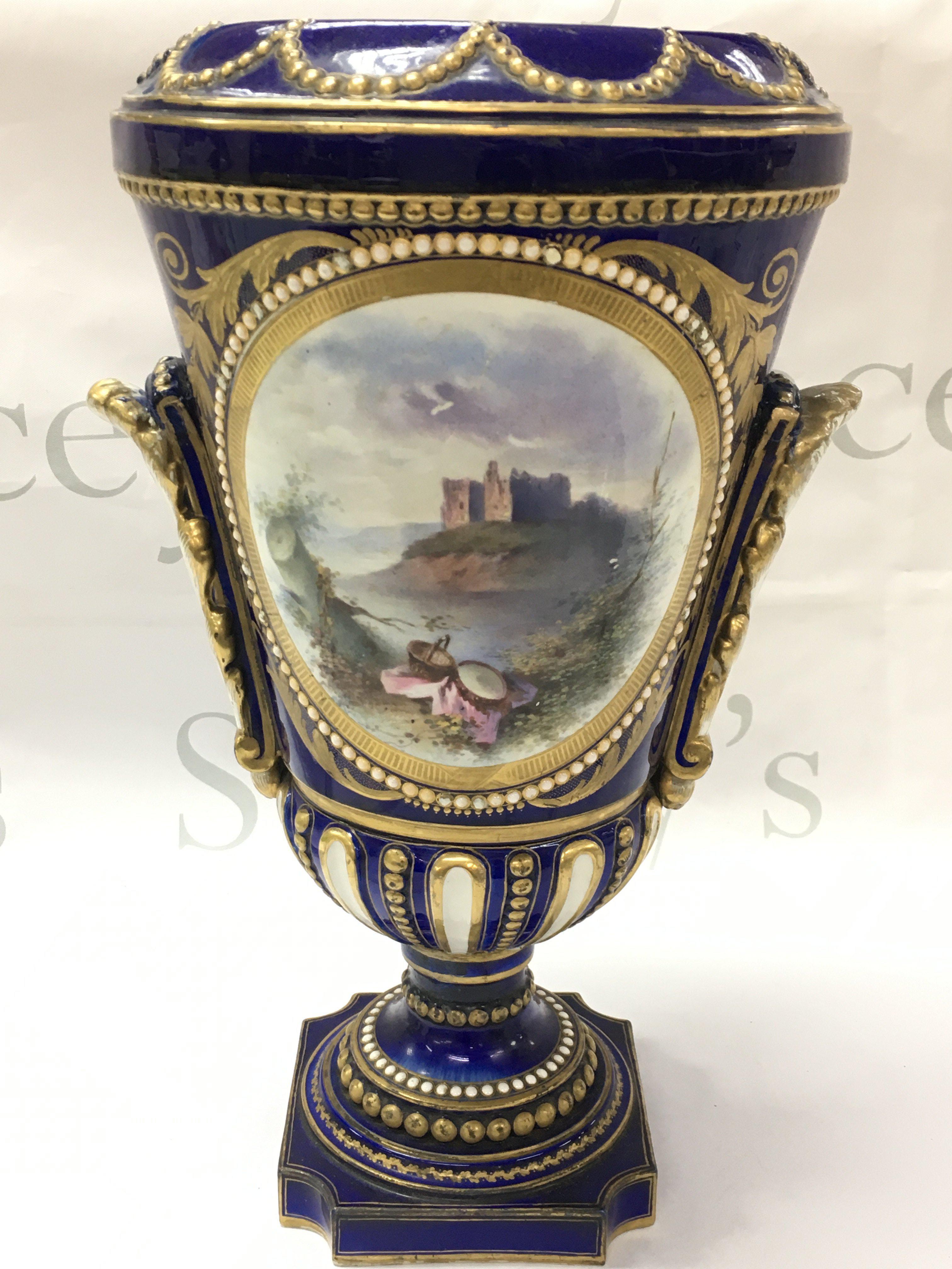 A Sevres style cobalt blue and gilt vase hand painted with panels of classical figures and a castle view. 34cm high, this lot cannot be posted .