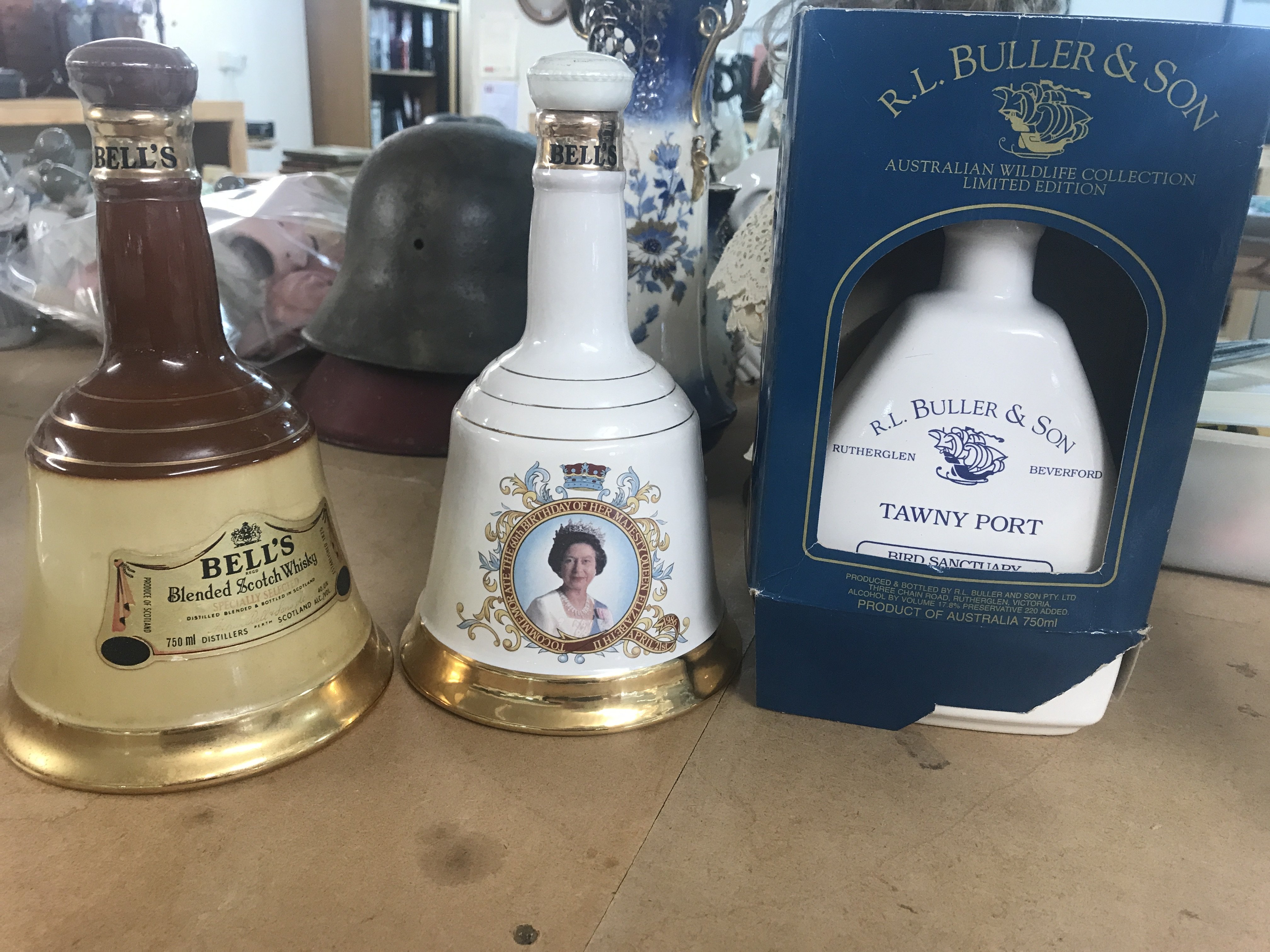 A bottle of Tawny port and two bells whisky decanters.