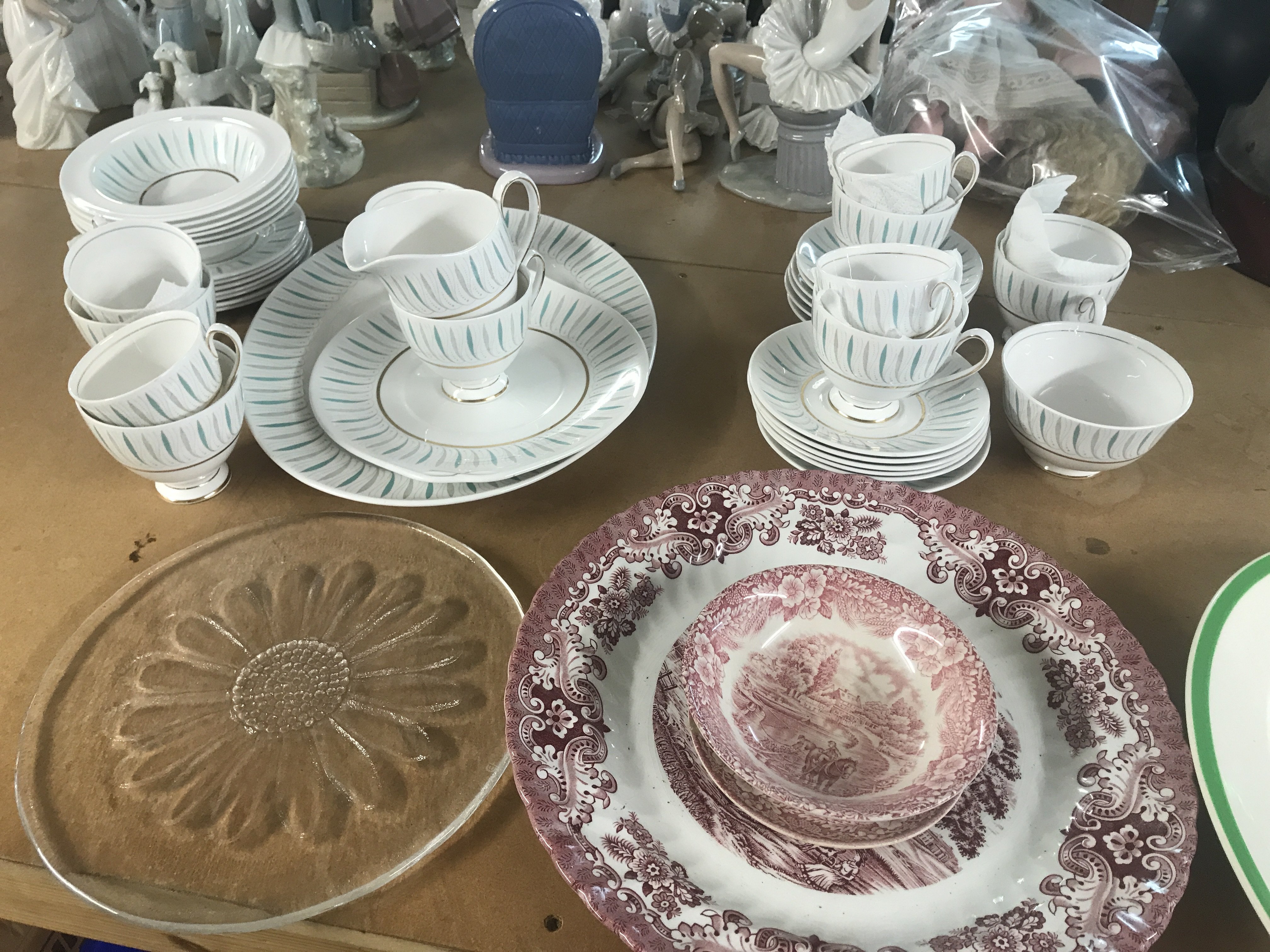 A Queen Ann tea set together with serving dishes in pink and a glass tray .