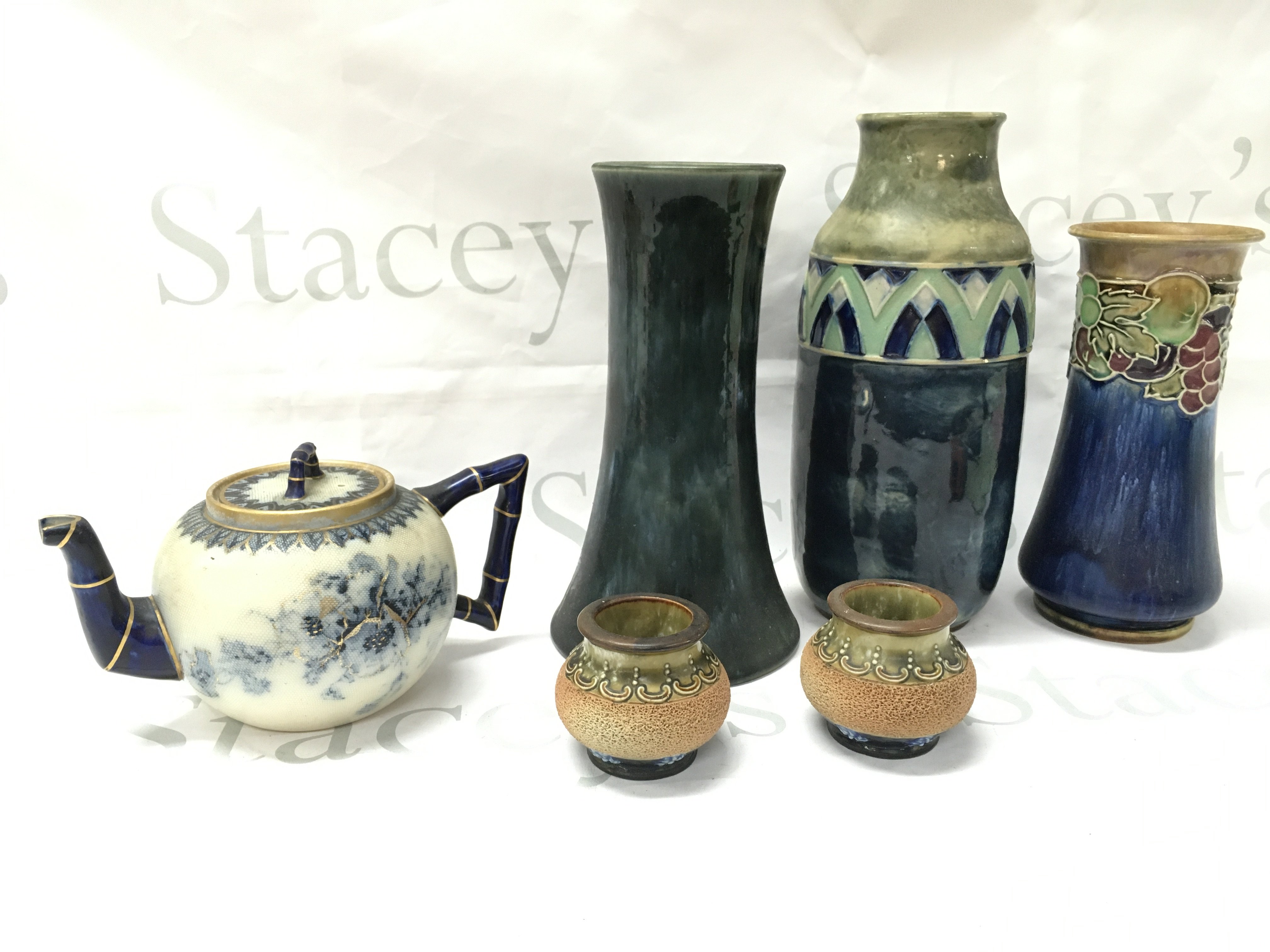 A collection of Royal Doulton stoneware vases and a Doulton Burslem US patient blue and white floral and gilt tea pot . This lot cannot be posted