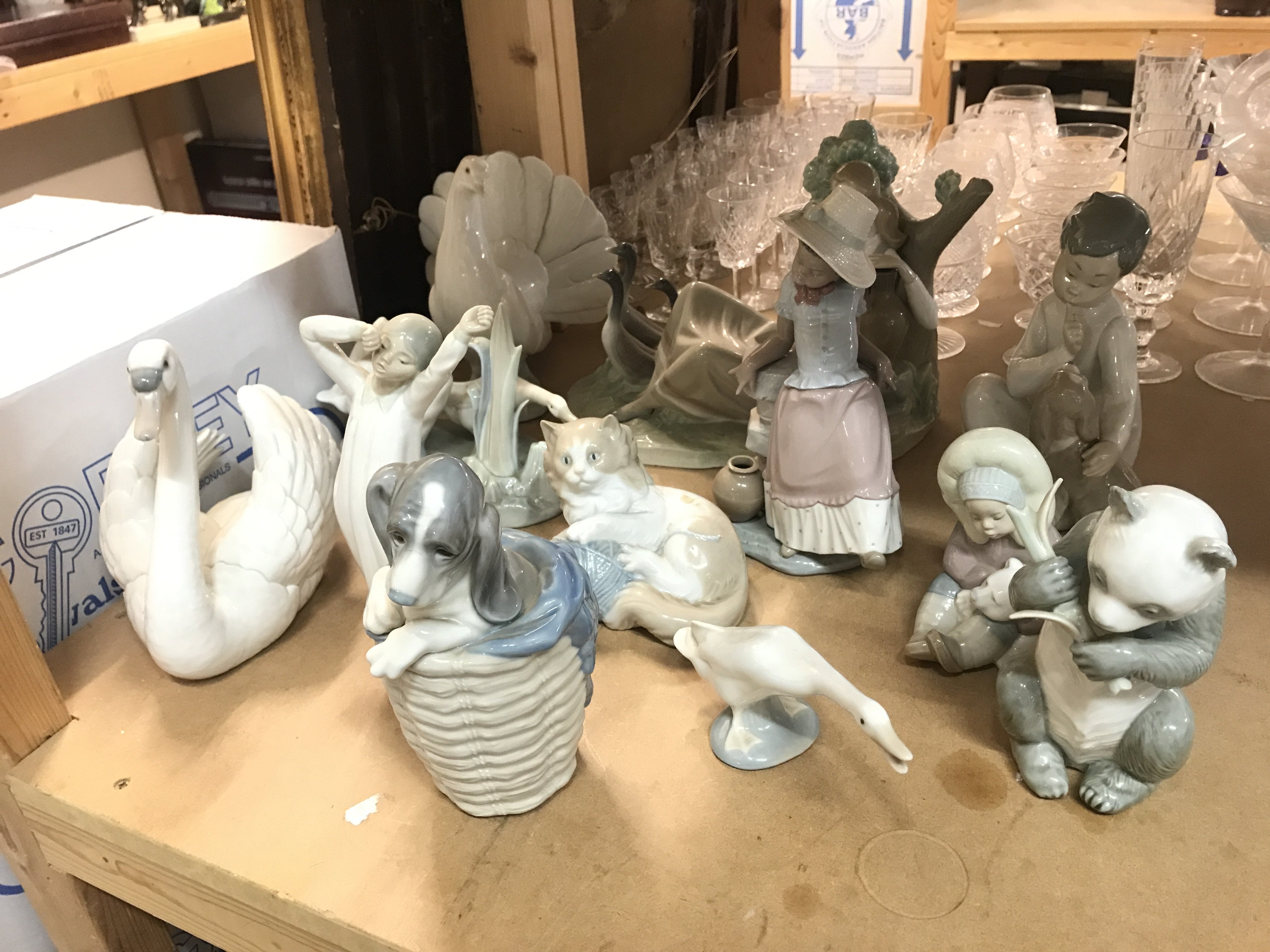 A Collection of Lladro and Nao figures including dog in a basket, dove, girl with geese(damaged) etc. this lot cannot be posted