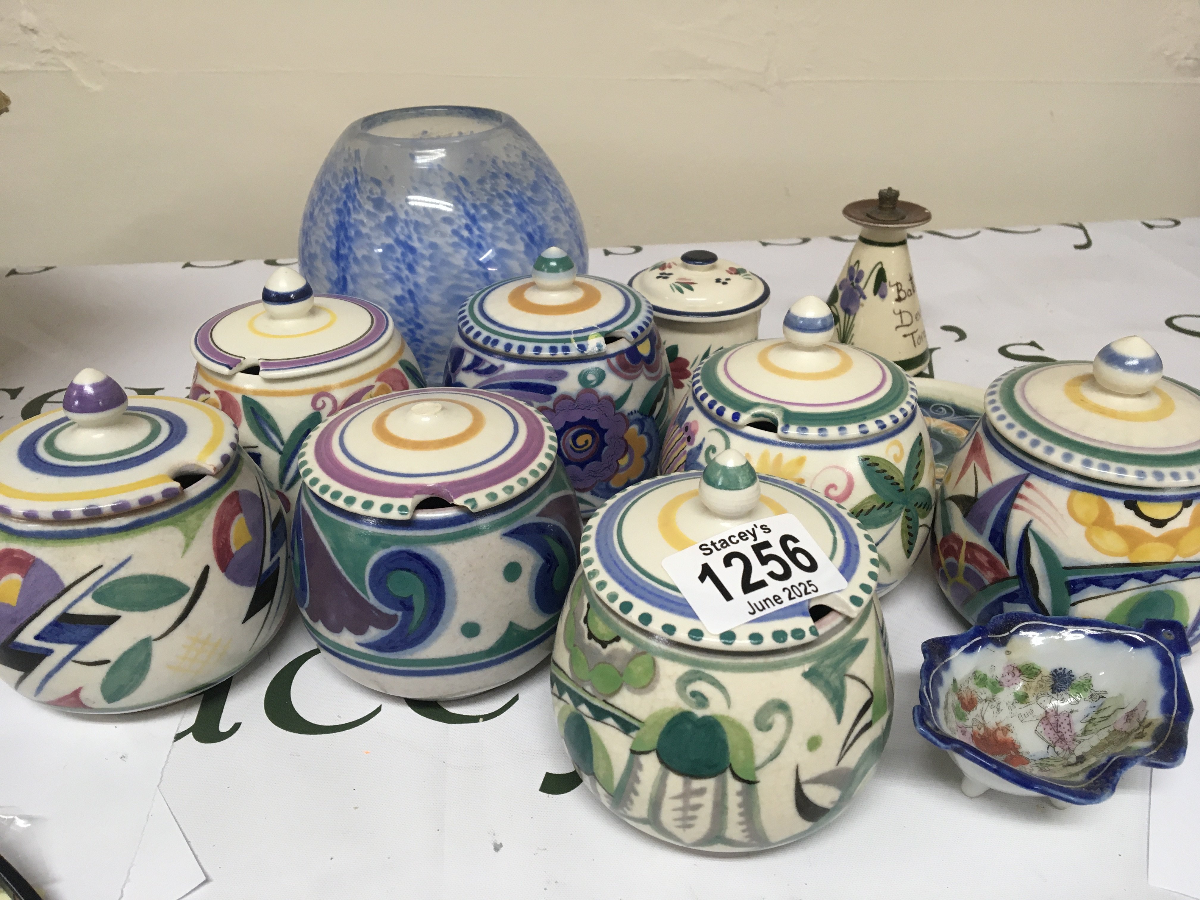 A collection of Poole pottery preserve pots hand painted an art glass vase and other ornaments. Some damage.