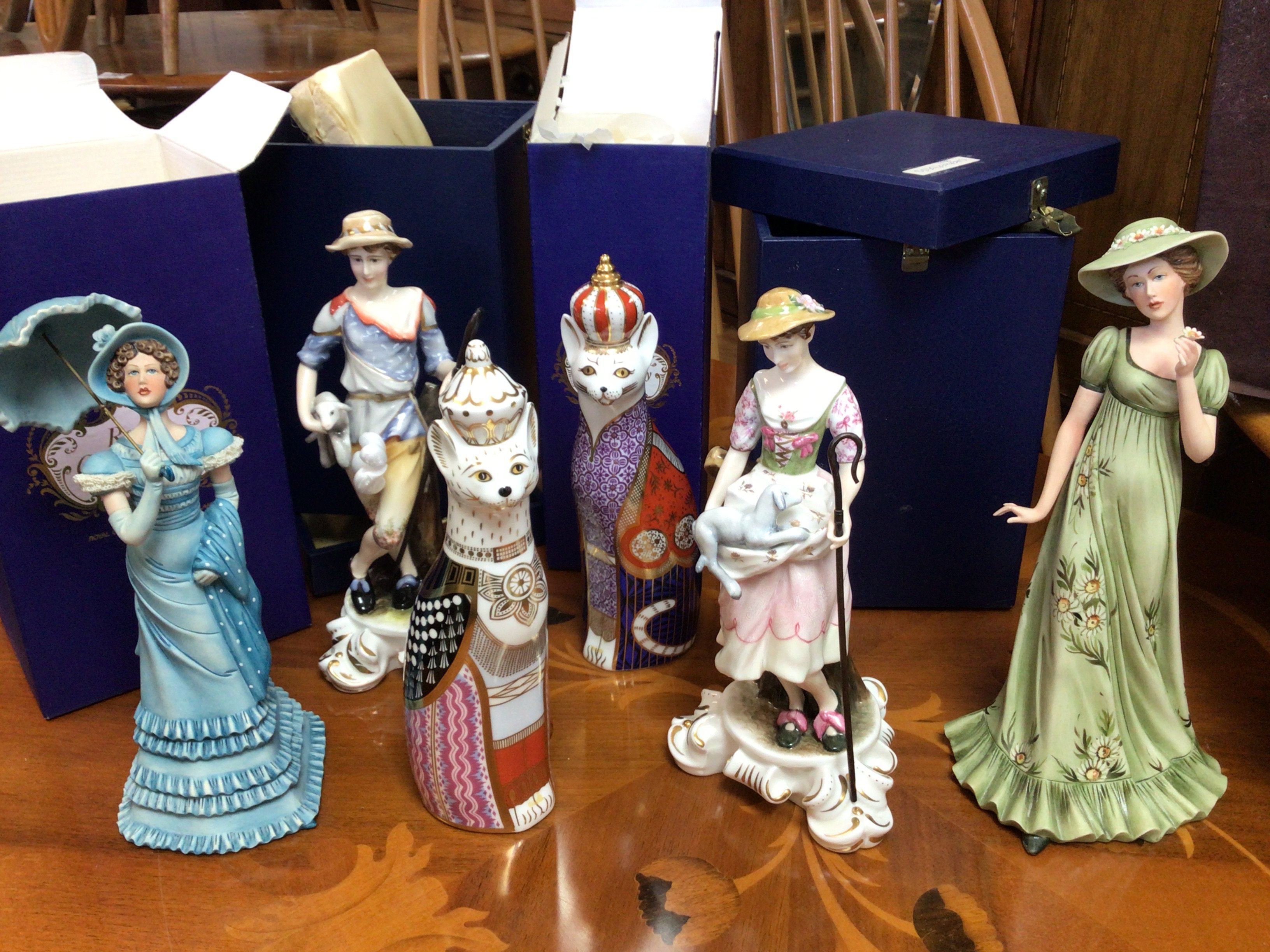 Four Royal Crown Derby boxed figures including Royal Cats and a Shepherd and Sheperdess, together with two boxed Limited Edition Capo-Di- Monte boxed figures with stands,