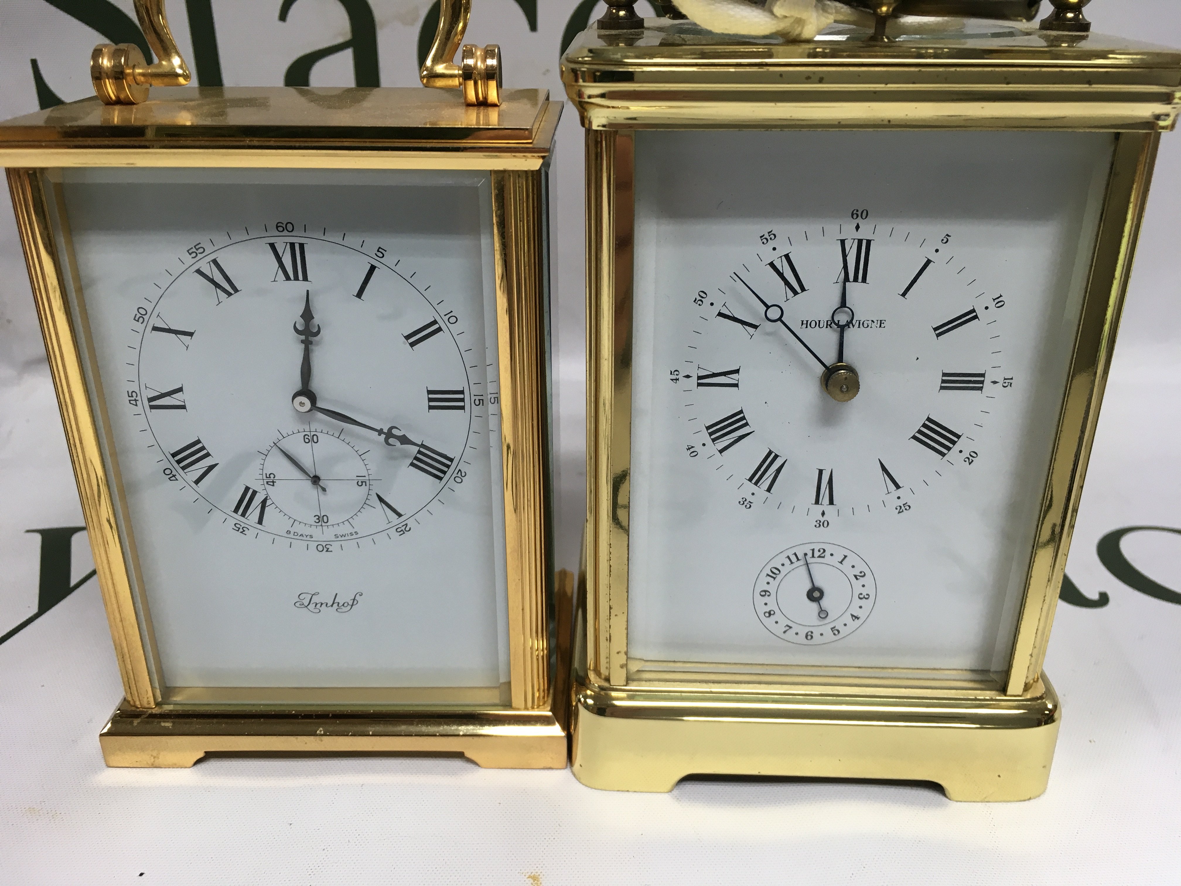 Two gilt carriage clock the dials with Roman numerals and second subsidiary dials one with strike repeat button.