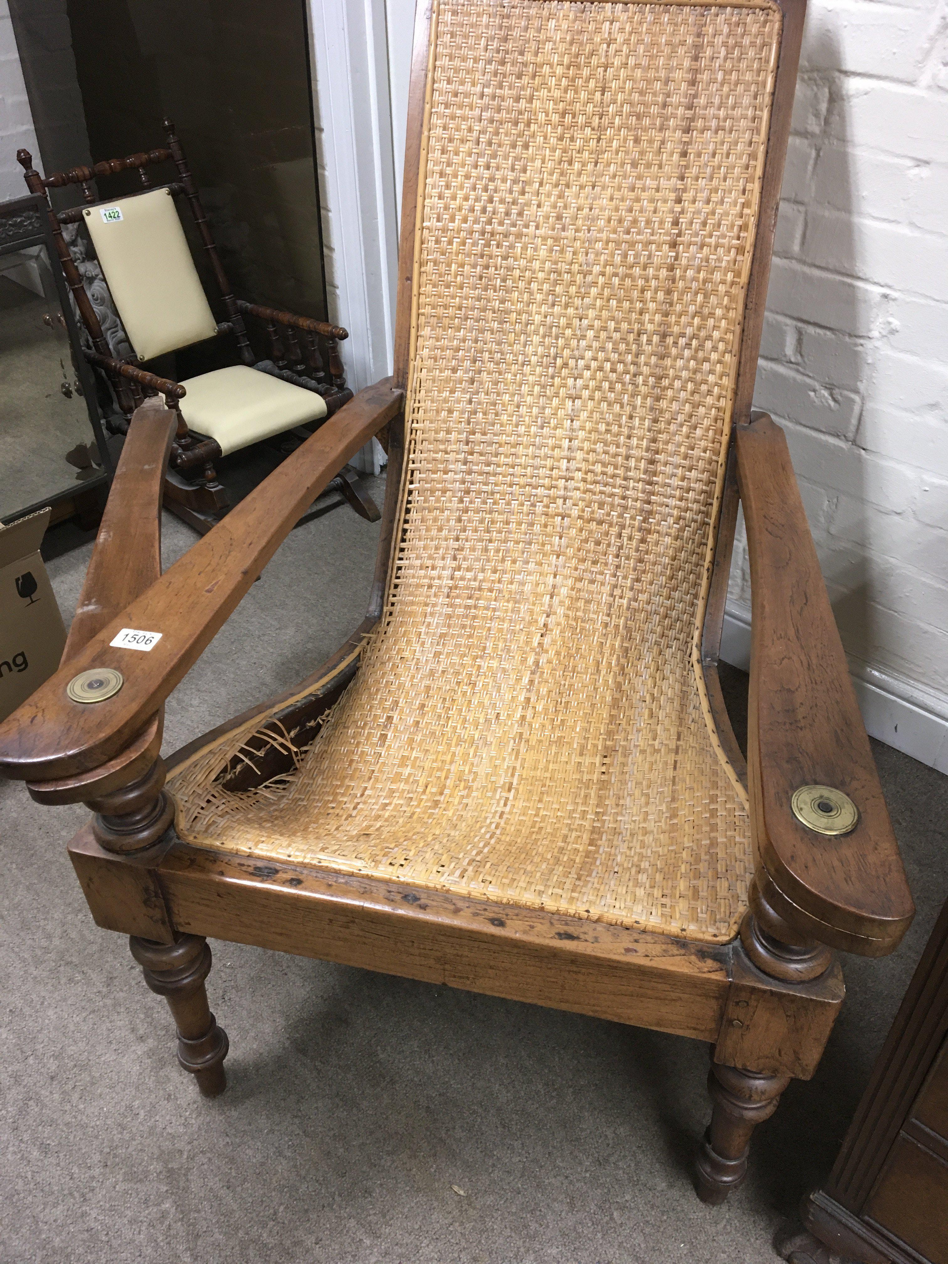 A Colonial reading chair with a woven wicker back and seat and hinged extending arm rests seat damaged. NO RESERVE