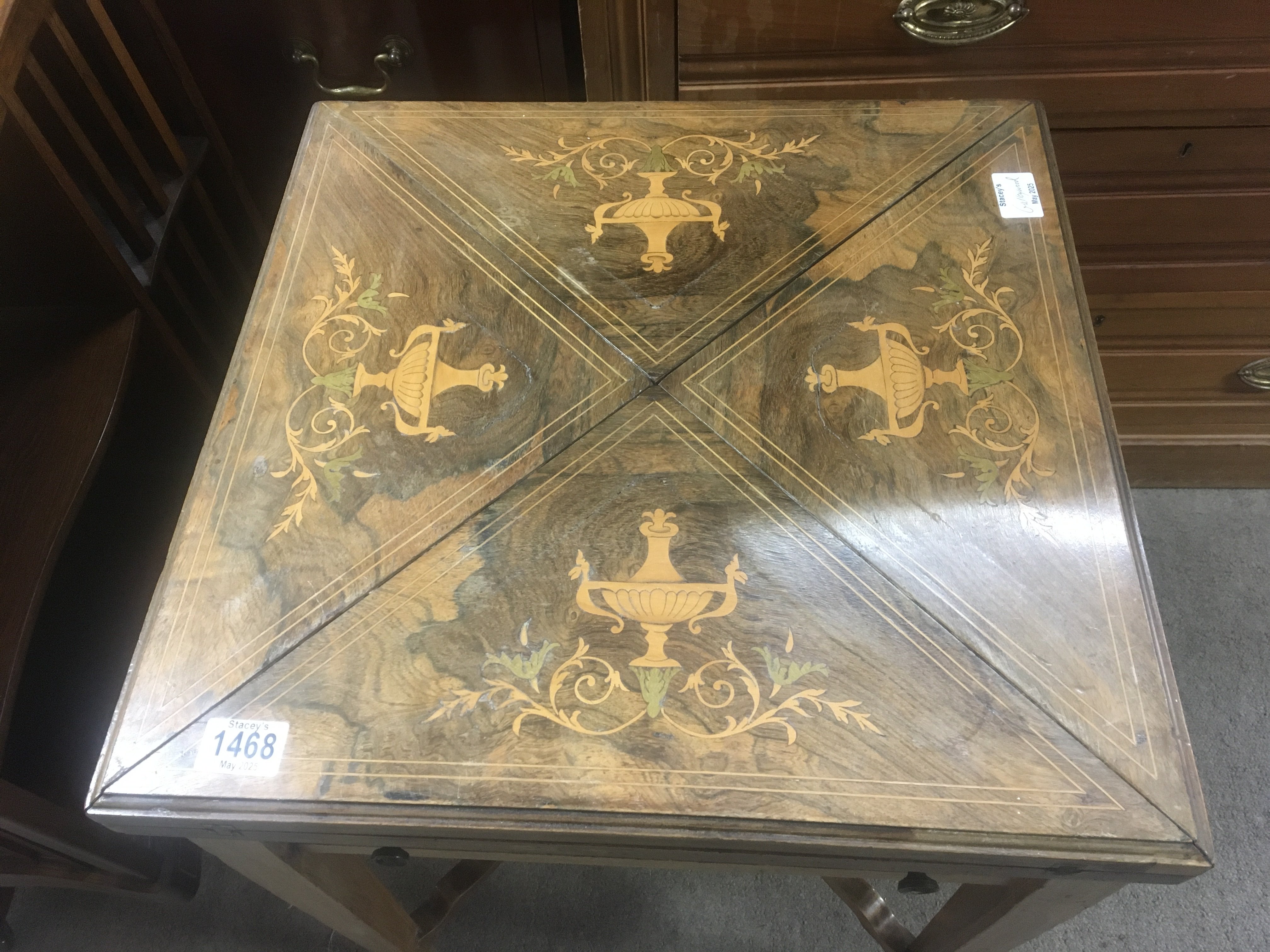 An Edwardian inlaid Rosewood envelope card table the quterd top inlaid with classical urns.