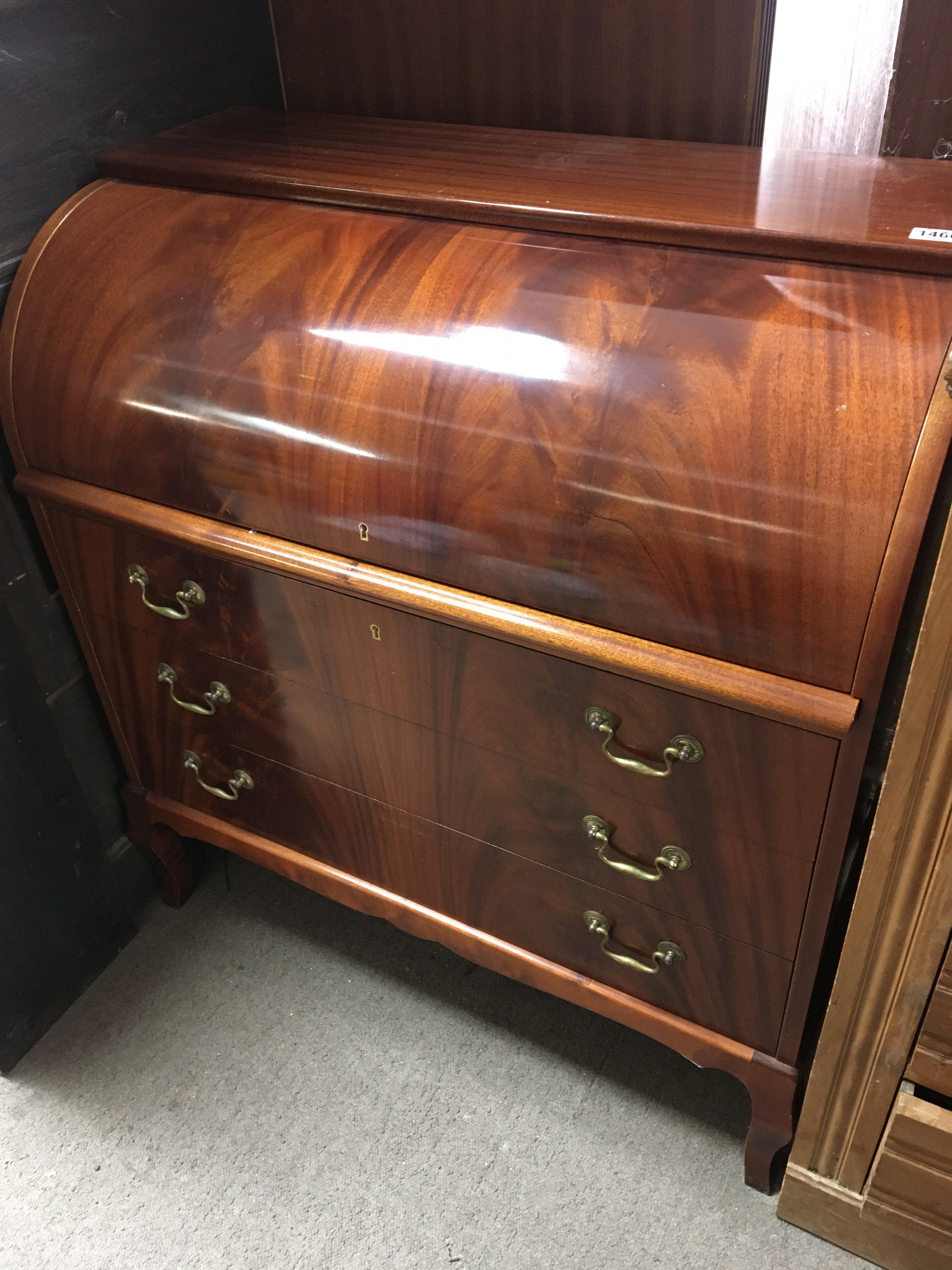 A Mahogany cylinder bureau with a solid roll top fitted interior above three drawers. 90cm wide