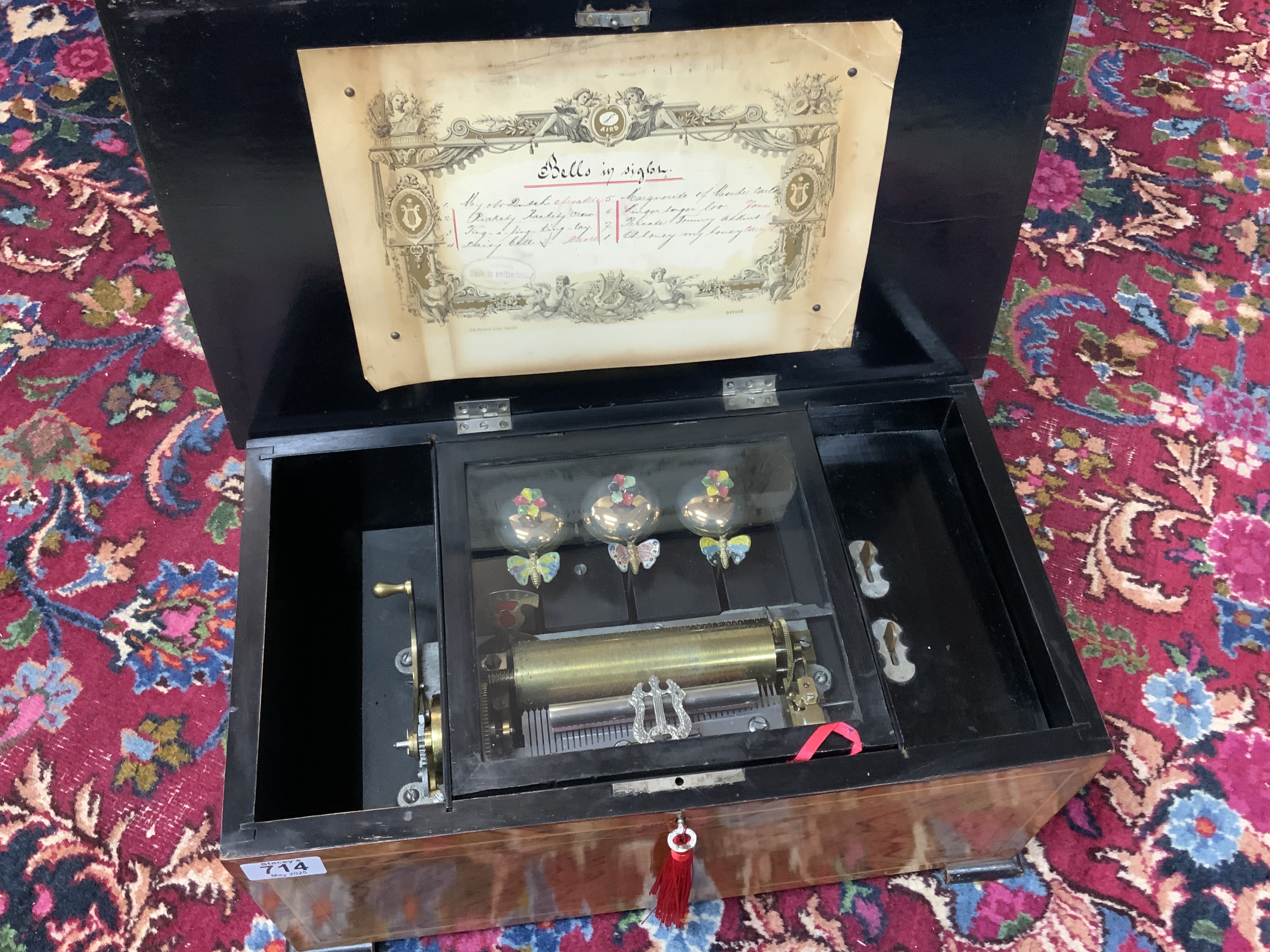 A Swiss cylinder musical box playing 8 airs as listed on tune sheet, marked Lith Picard - Lion, Geneve. 15 cm cylinder with 3 bell accompaniment. Brazilian Rosewood veneer to front and lid. Working condition. (D) 48cm x 27.5cm x 22cm.