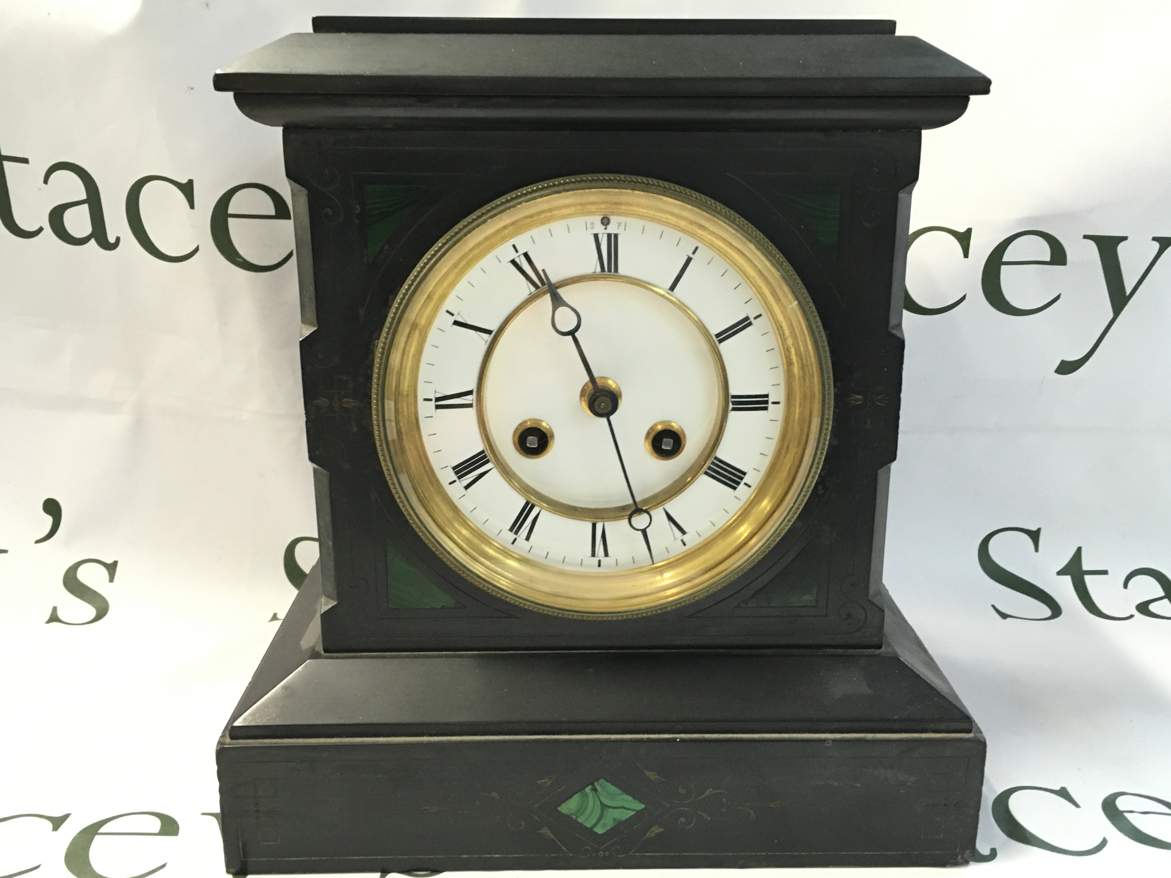 A slate mantle clock with a white enamel Roman numeral face and green stone inlay . Seen working. This lot cannot be posted
