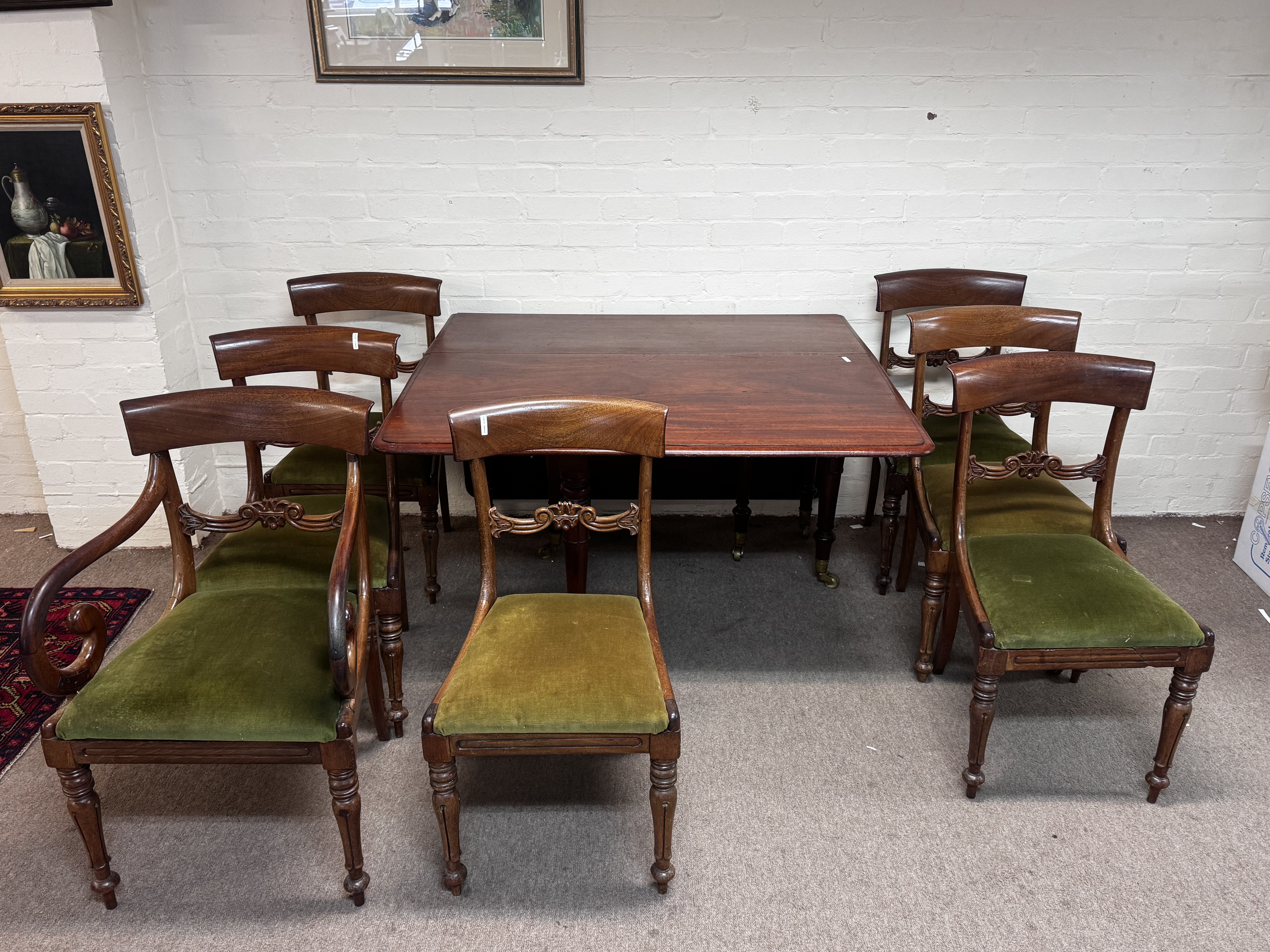 An Early Victorian mahogany drop leaf dinning table and a set of eight mahogany dining chairs with drop in seats including a pair of open are chairs with scrolls. (D)