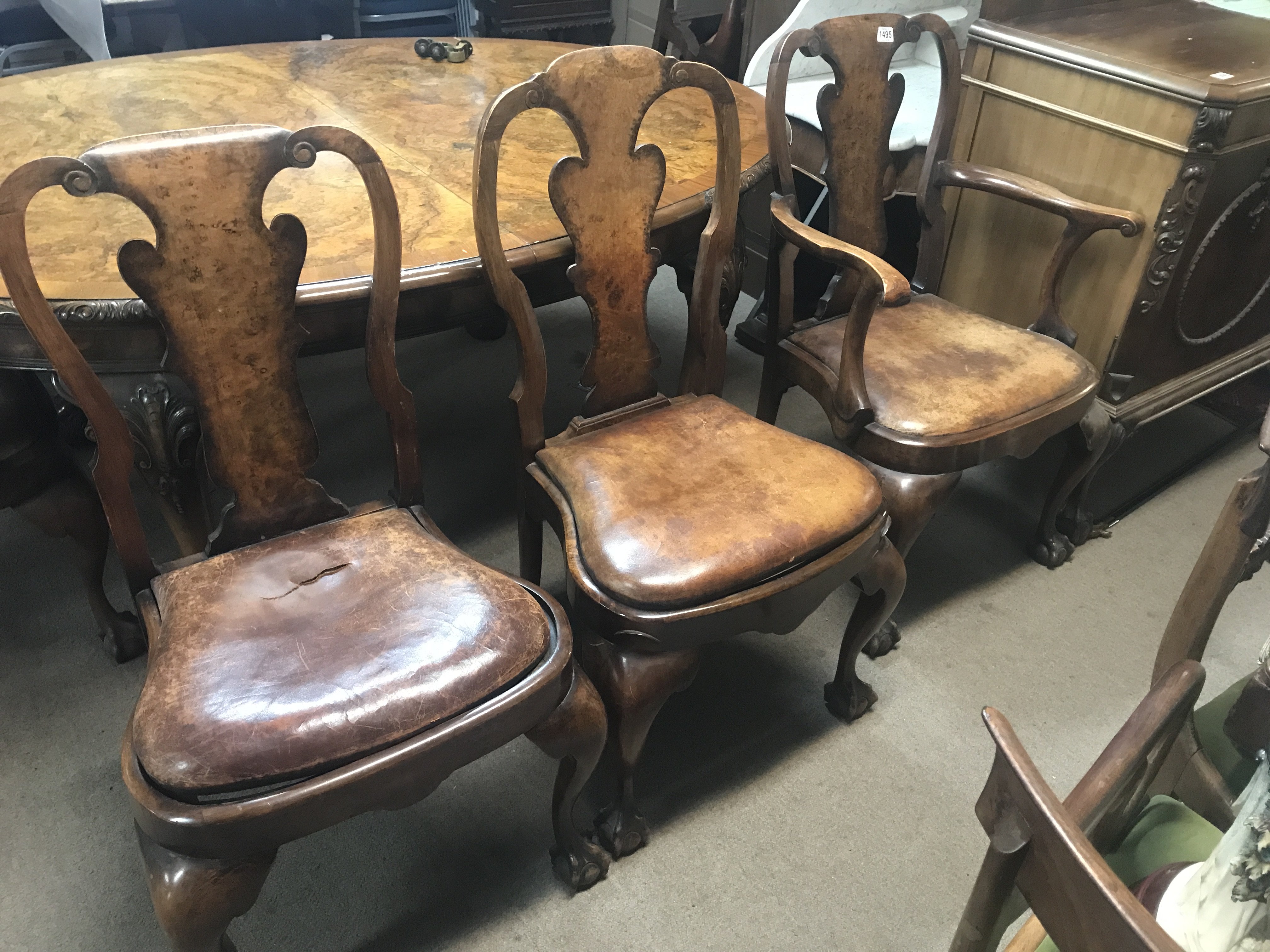 A walnut dining table with extra leaf together with a set of eight chairs including two carvers .