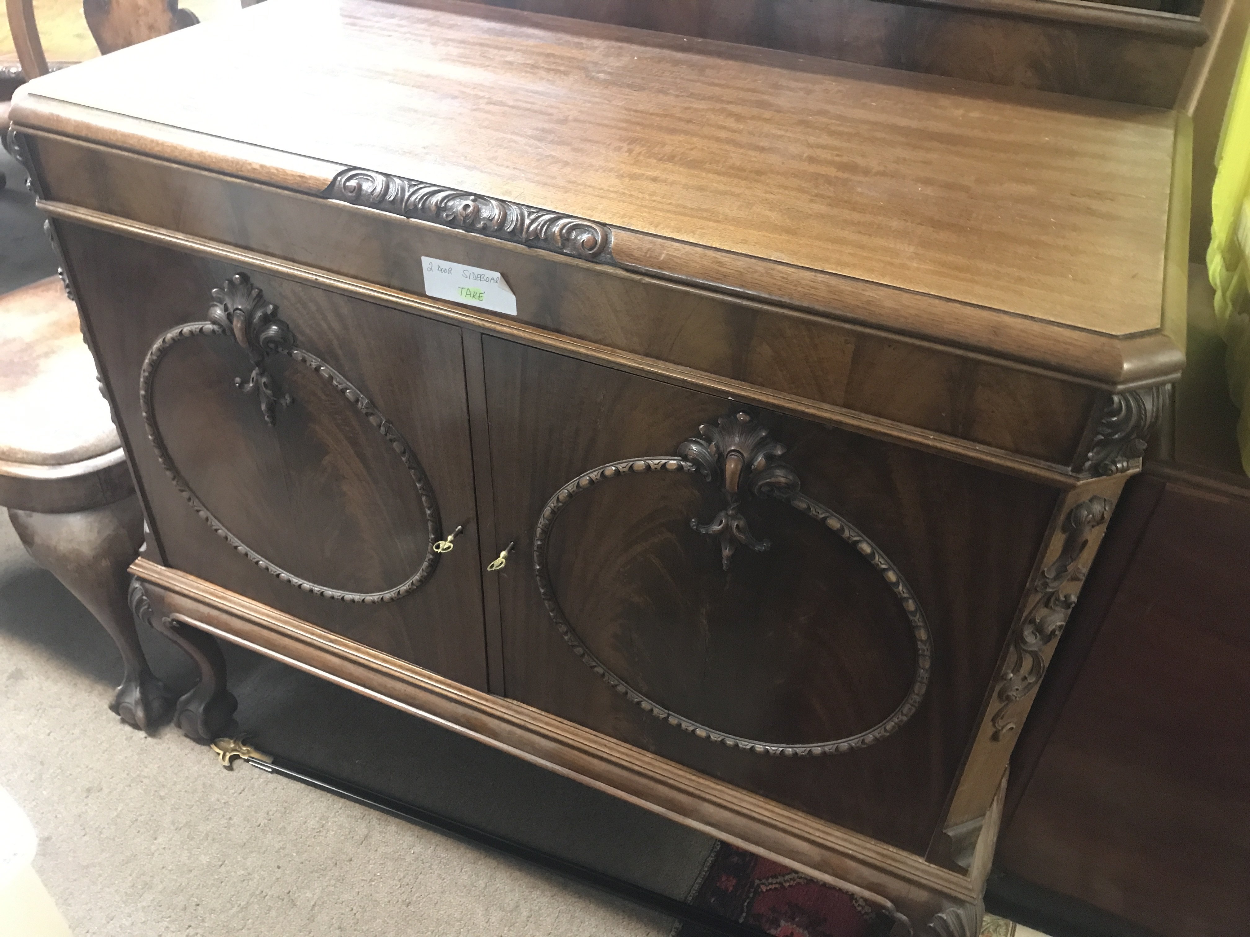 A mahogany side cabinet the raised back above a pair of door on cabriole legs .