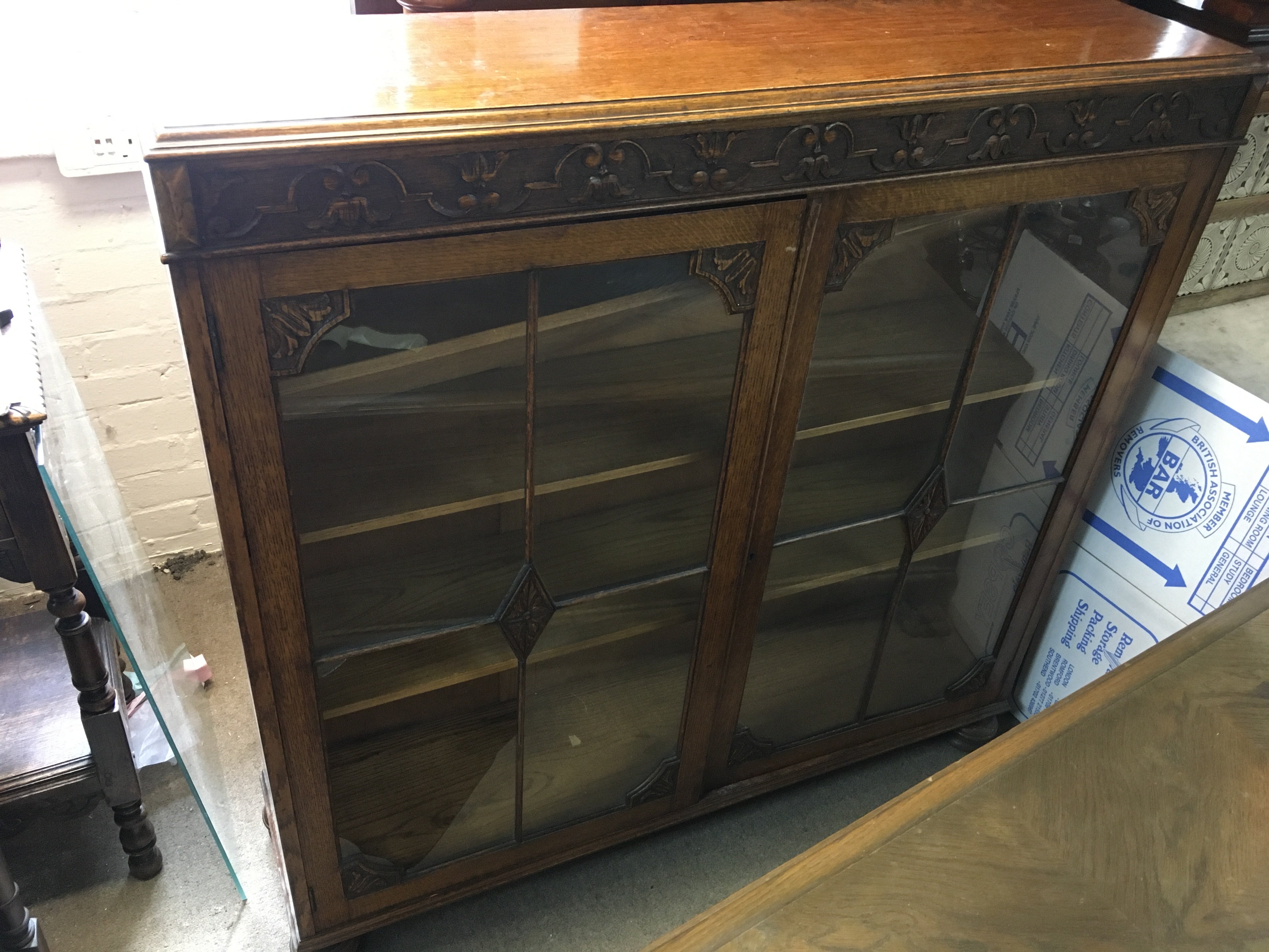 A carved design oak double door cabinet, in need of restoration. Dimensions 122x30x123cm